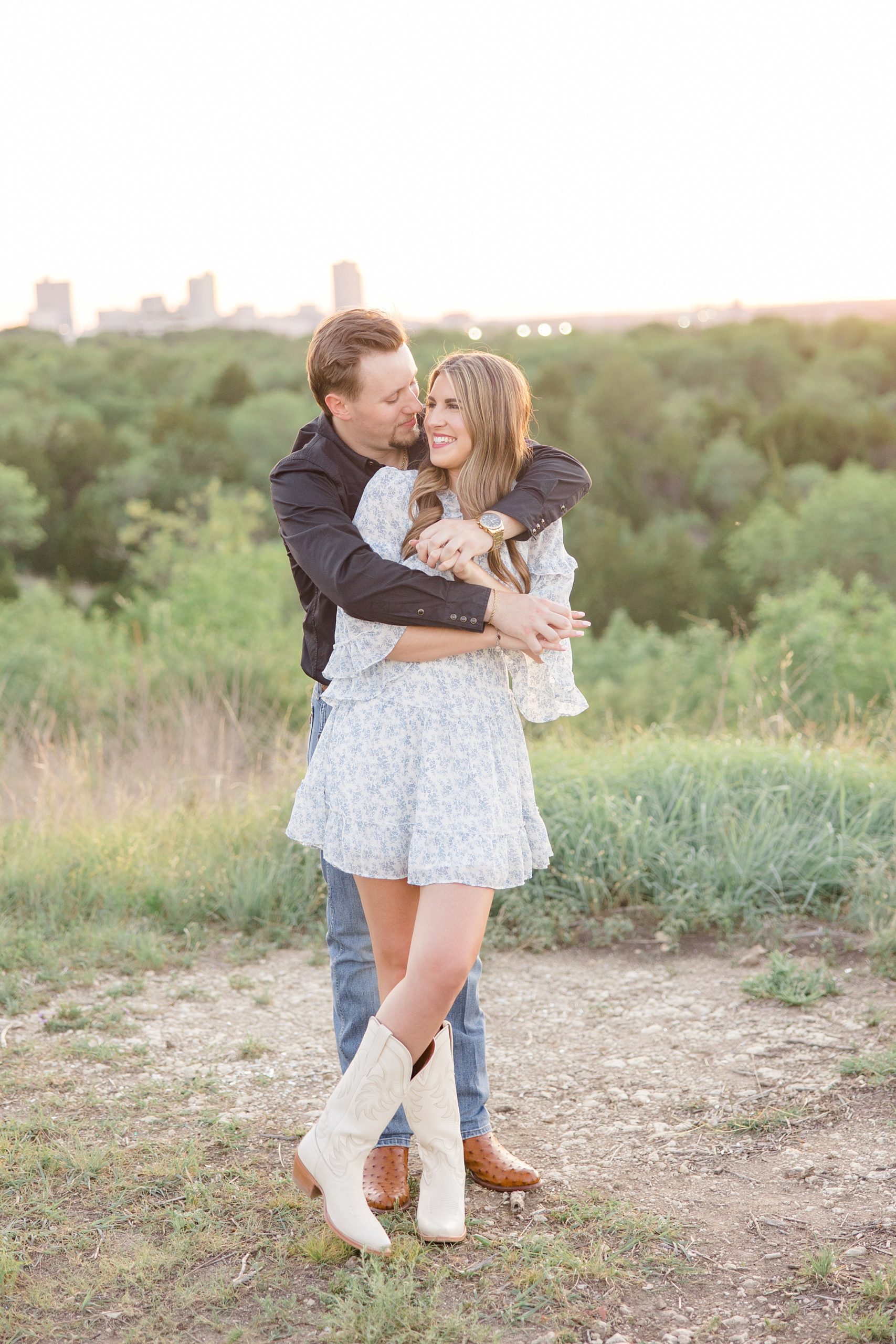 man hugs bride during engagement session at sunset in Texas