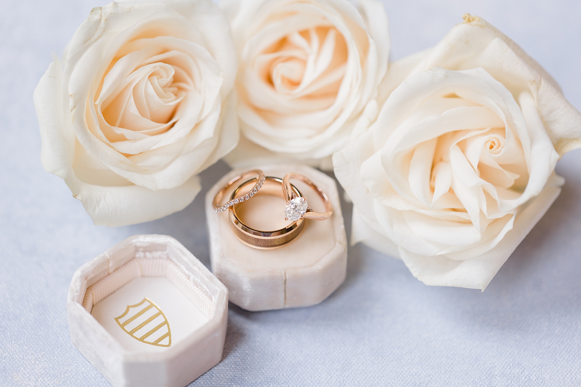 gold wedding bands rest on ivory ring box