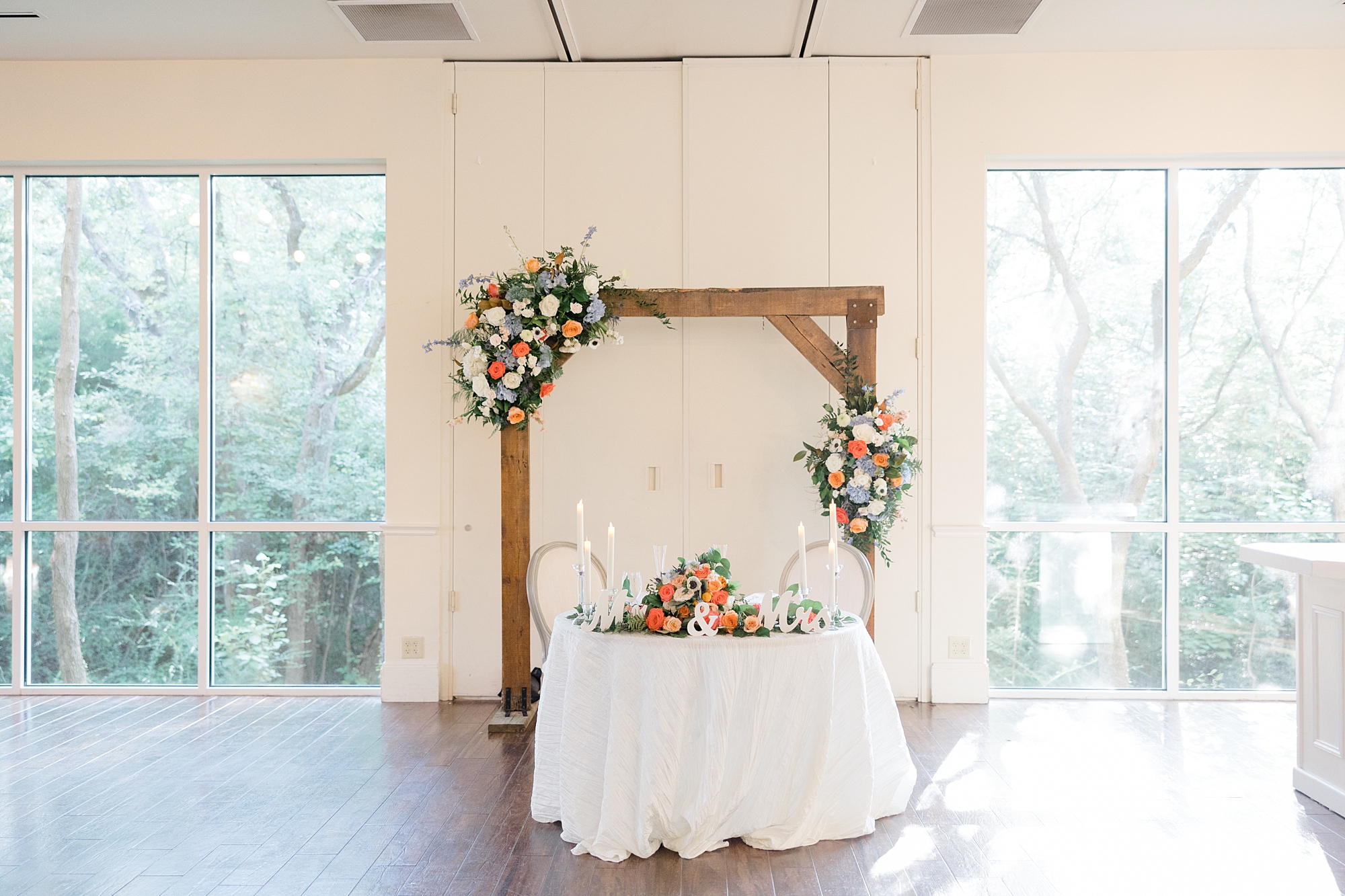 sweetheart table with wooden arbor above it at Ashton Gardens wedding reception 