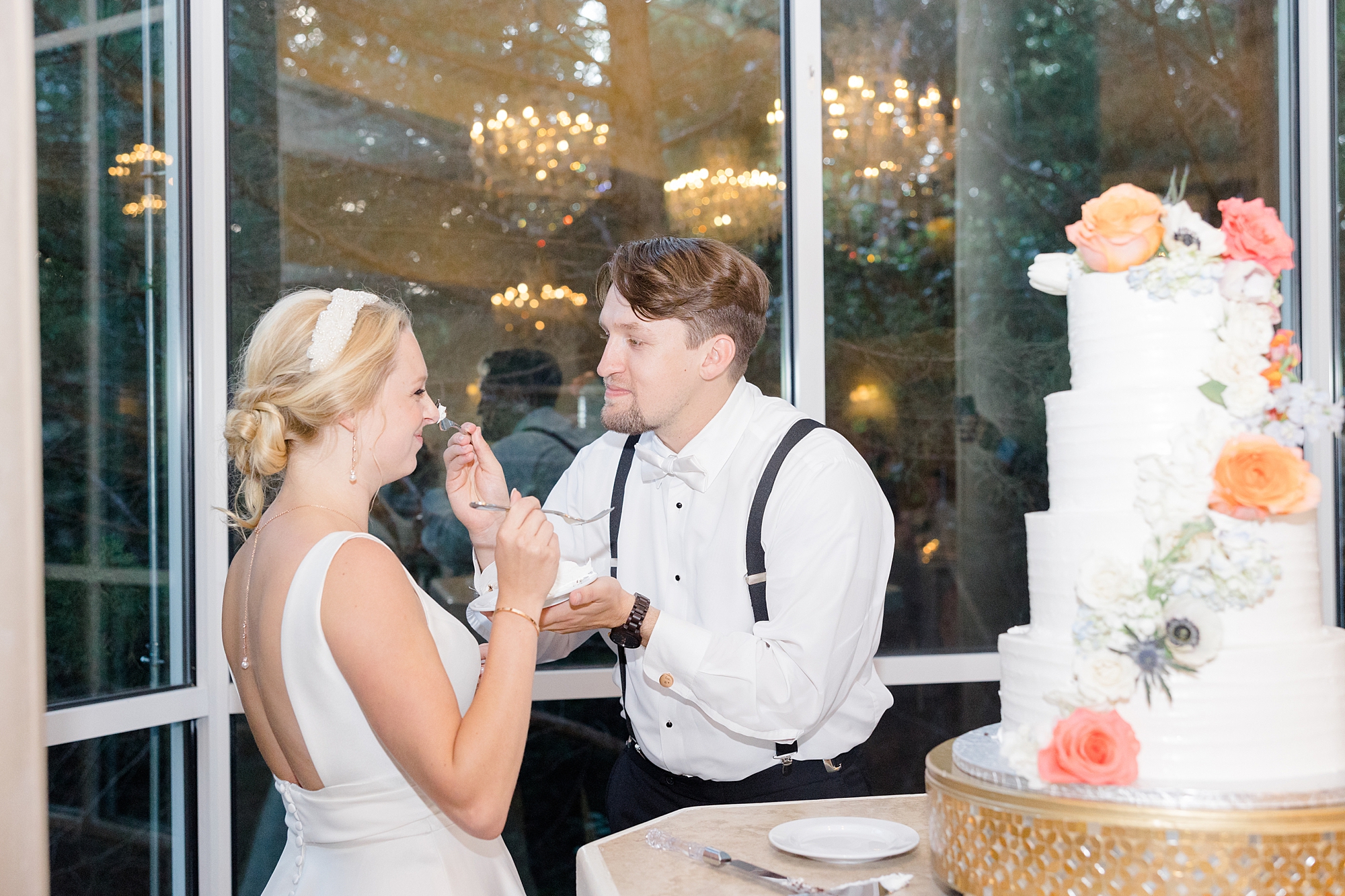 groom feeds bride cake during Corinth TX wedding reception