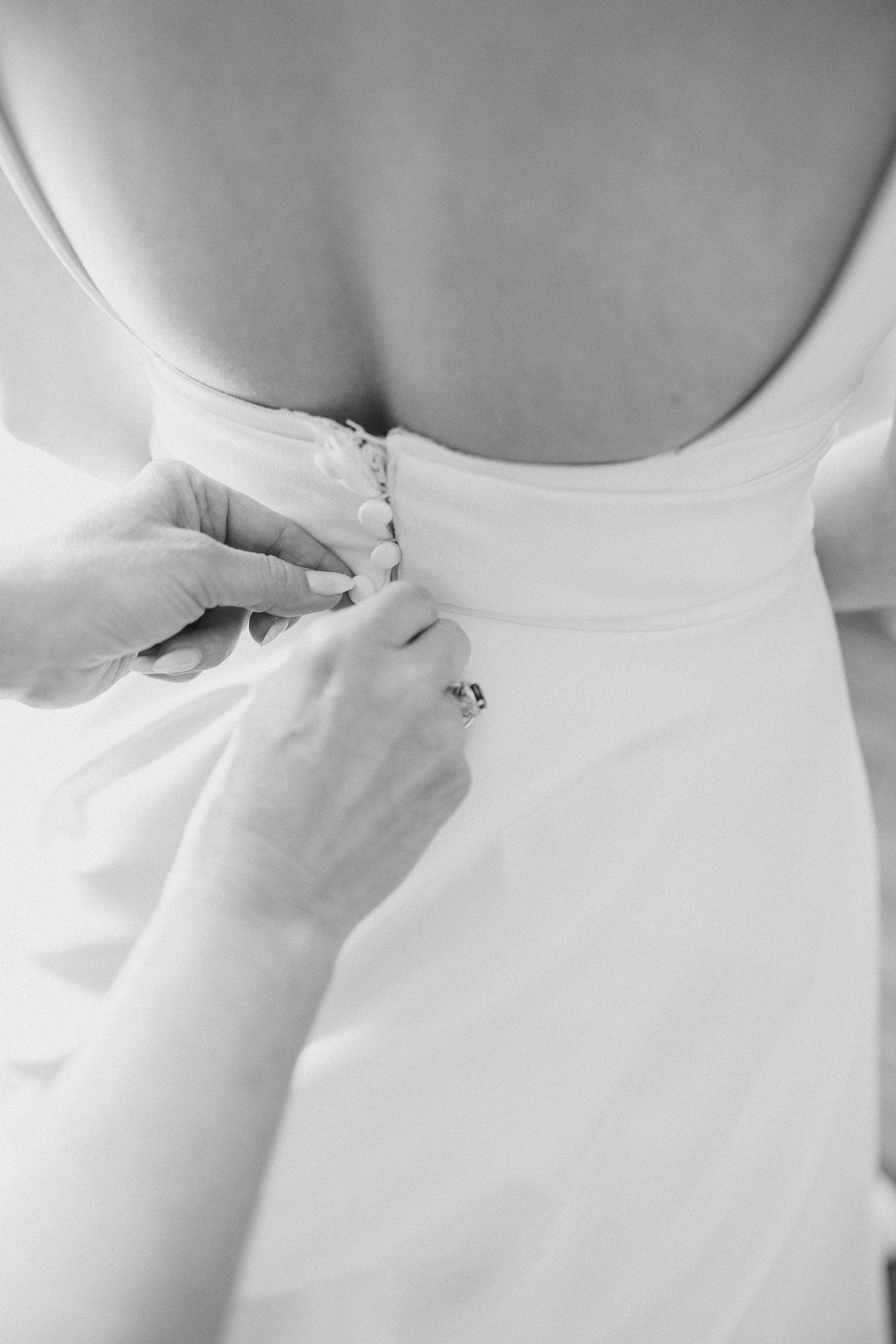 mother helps bride with wedding gown before Ashton Gardens wedding