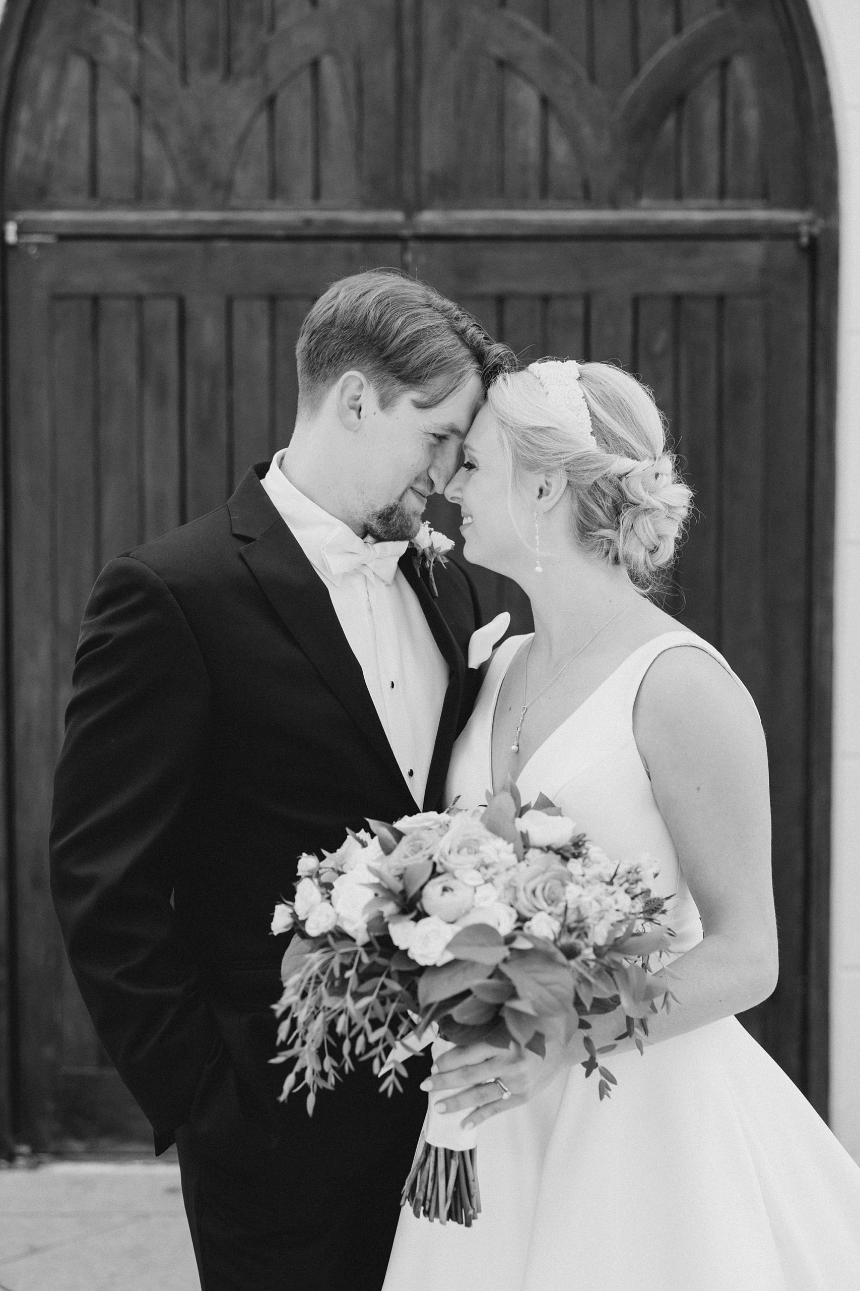 newlyweds lean foreheads together during wedding portraits at Ashton Gardens