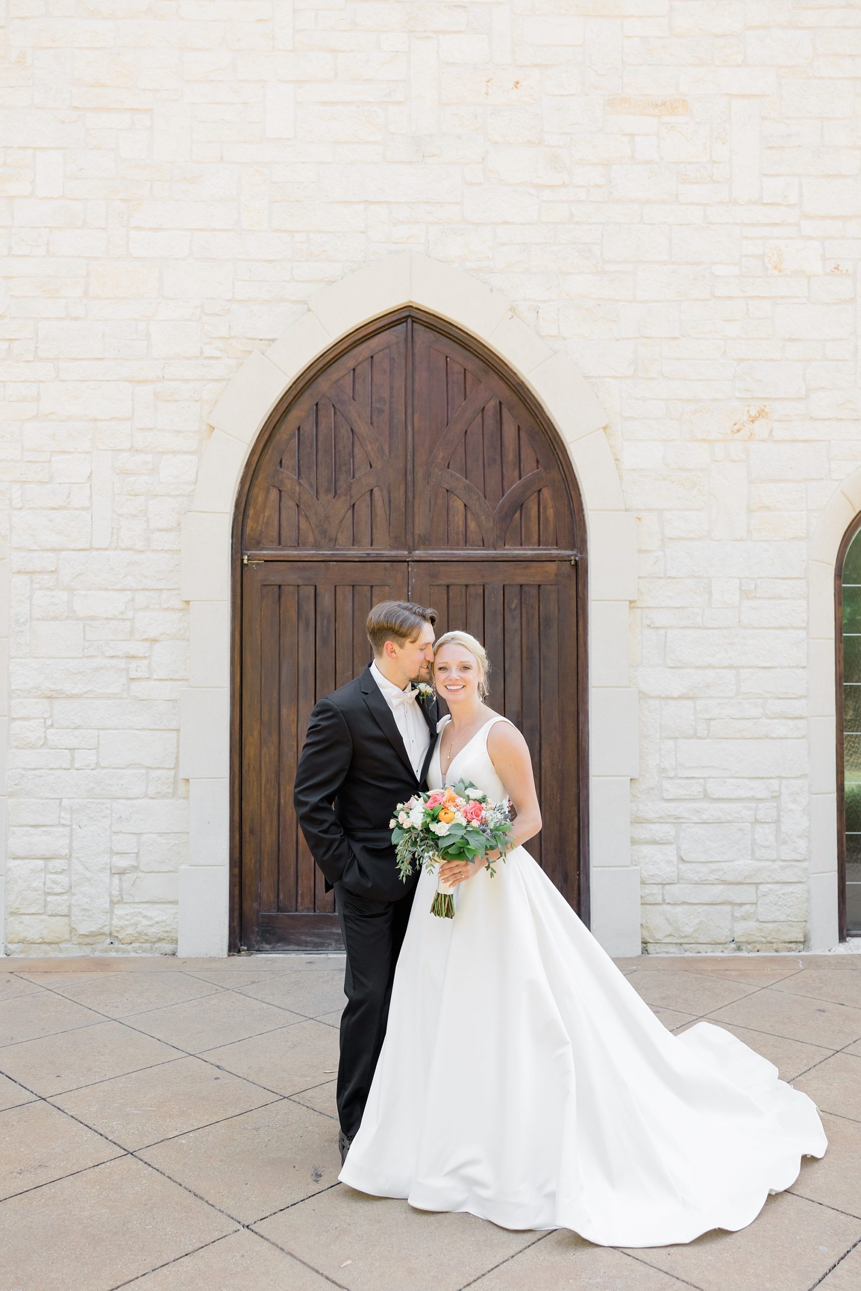 groom kisses bride's forehead during TX wedding photos 