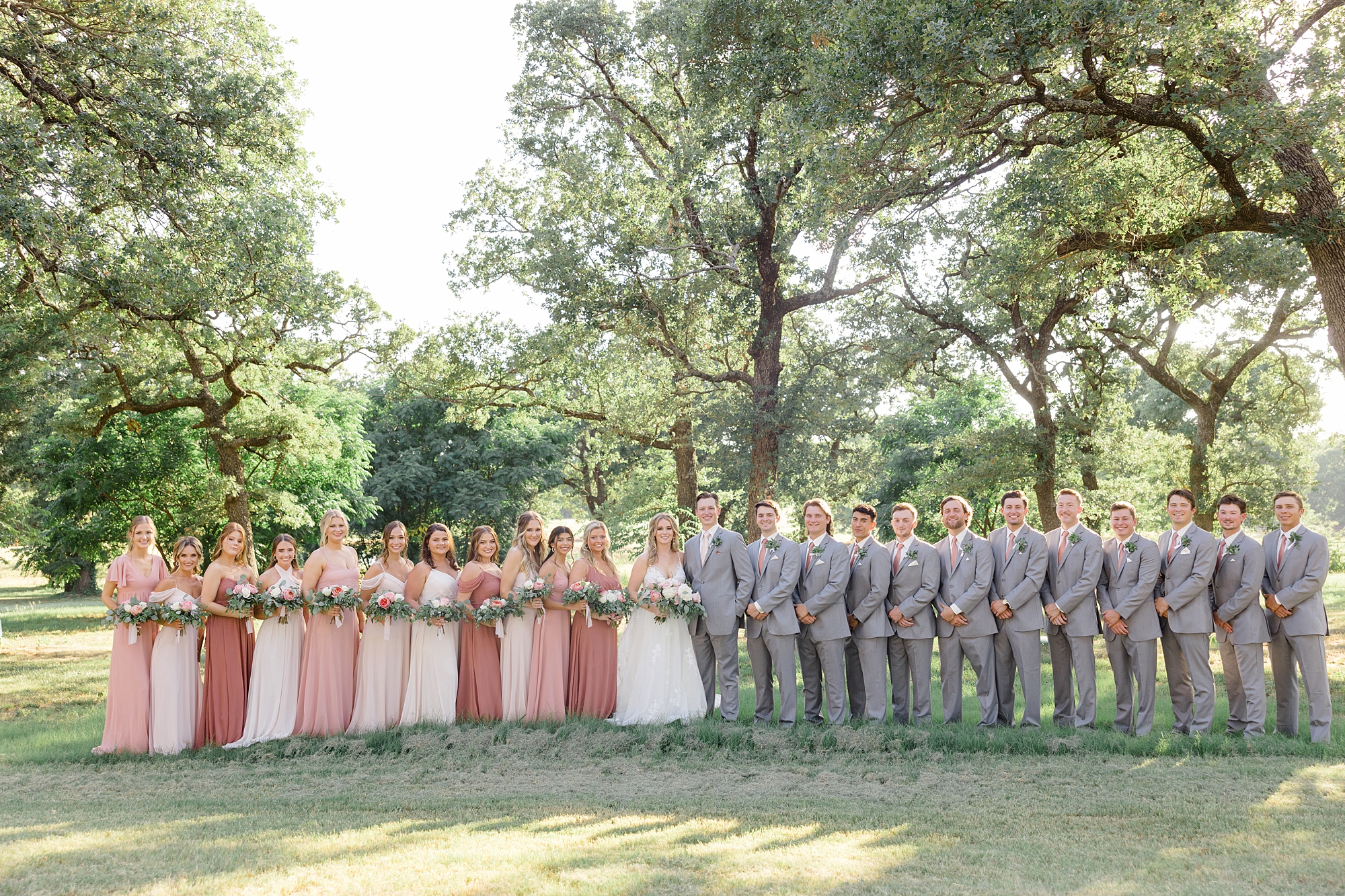 bride and groom stand with wedding party in Dallas TX