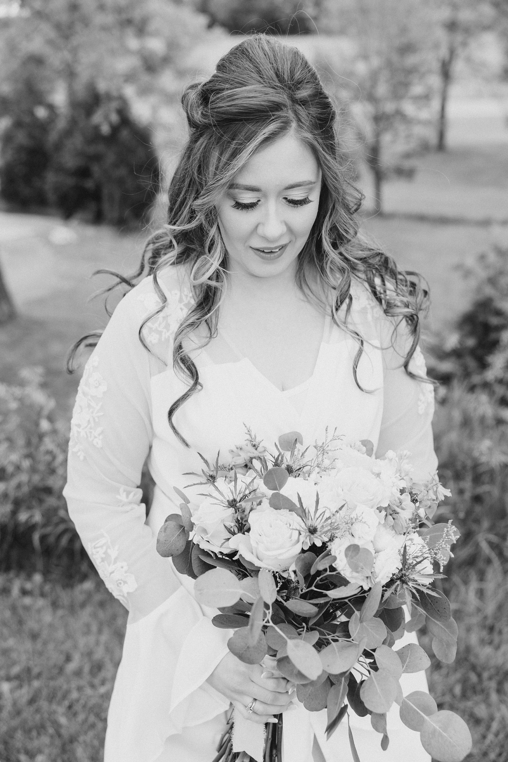 bride looks down at bouquet during portraits at the Barn at Stoney Creek