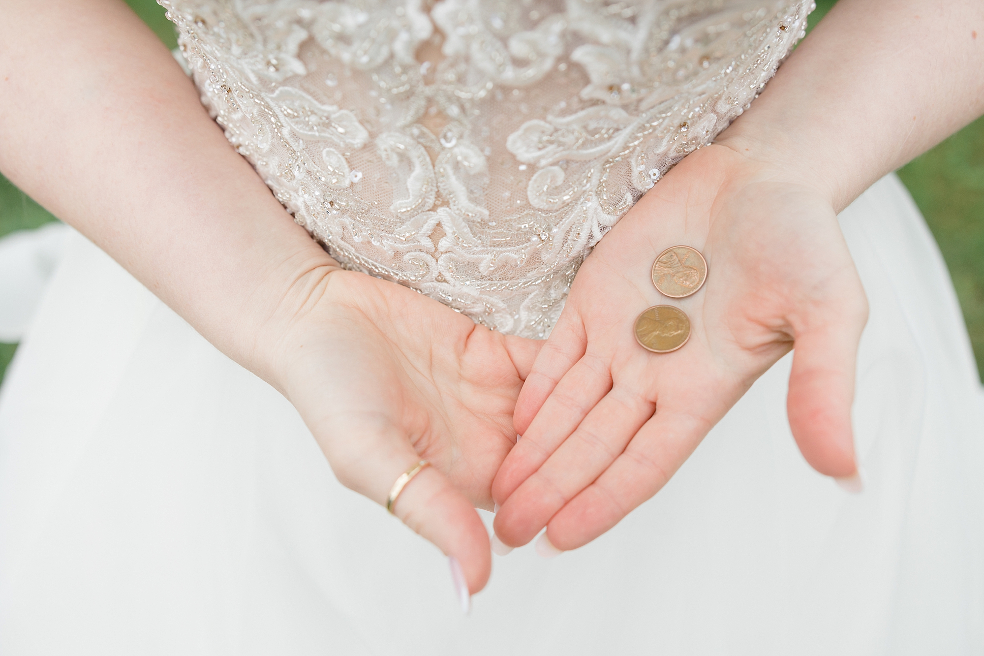 bride holds coins in her hand on wedding day