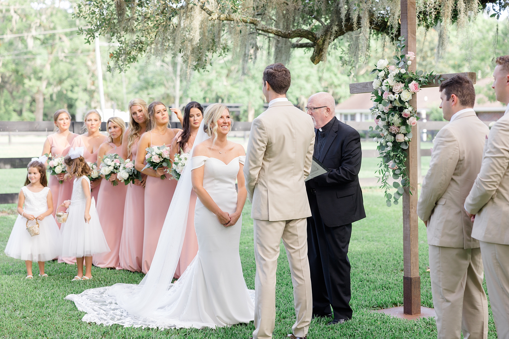bride and groom hold hands during ceremony at Boone Hall