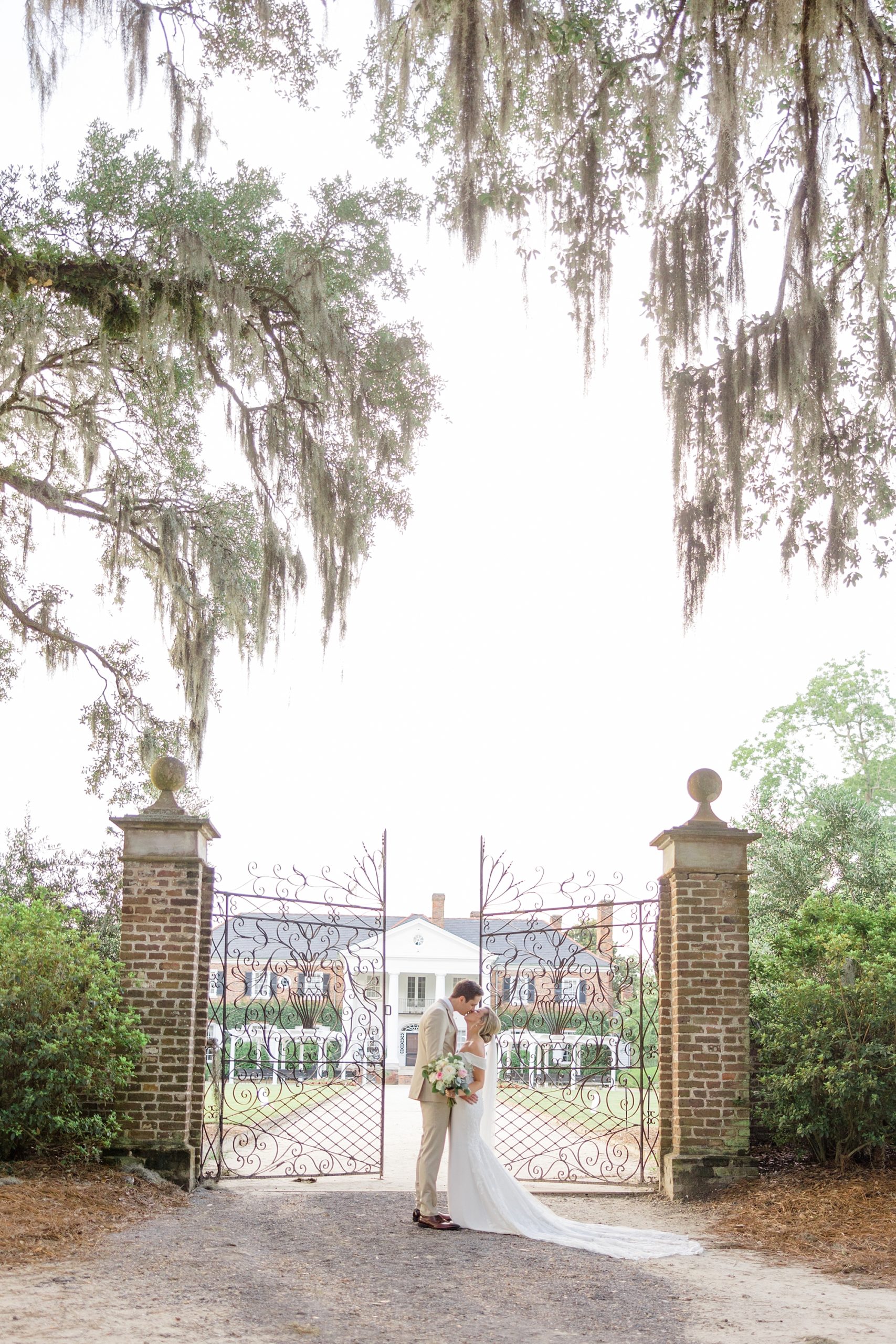 bride and groom kiss outside the gates of Boone Hall in Charleston SC