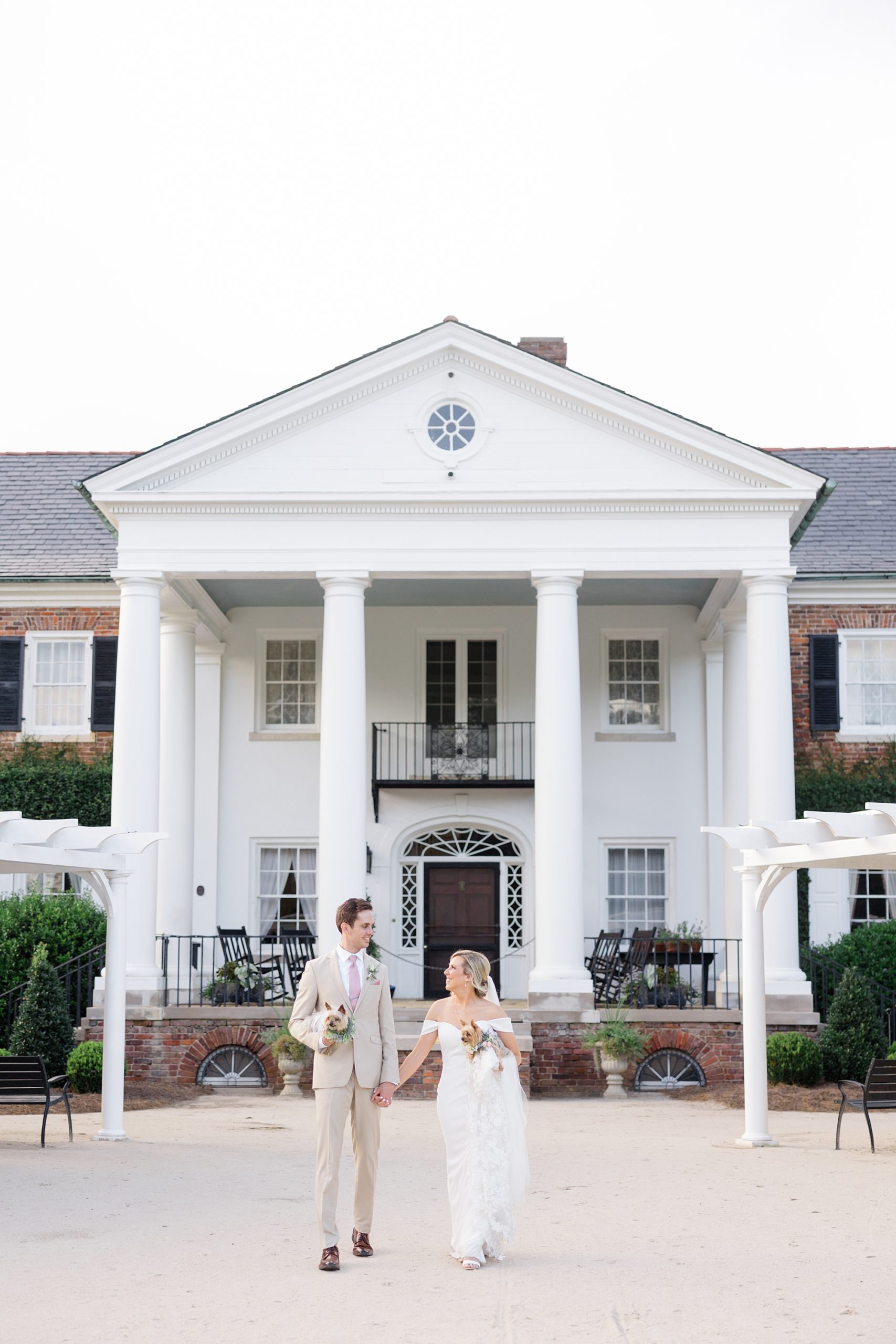 newlyweds walk outside front porch of Boone Hall