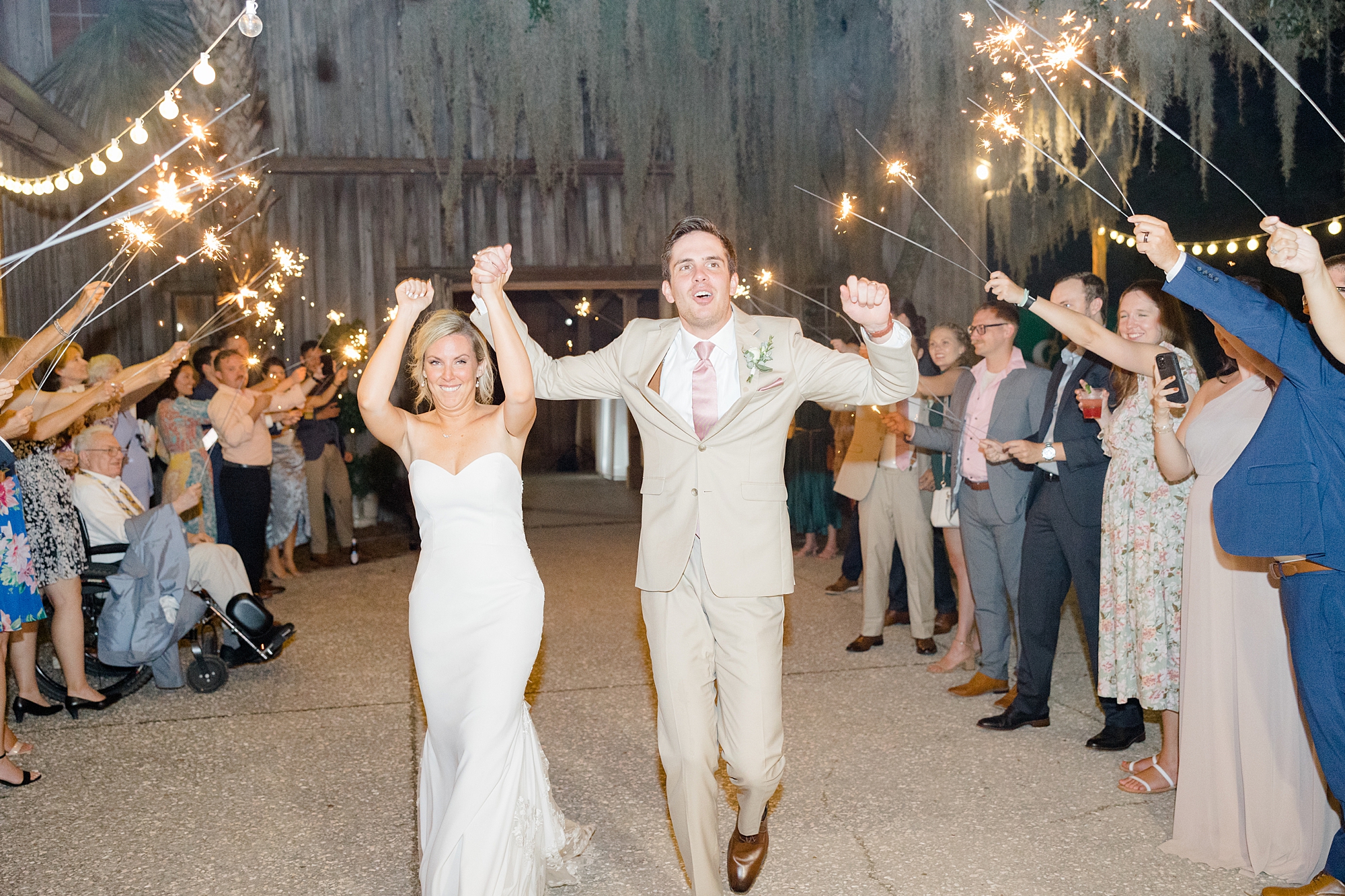 bride and groom cheer leaving Boone Hall with sparkler exit