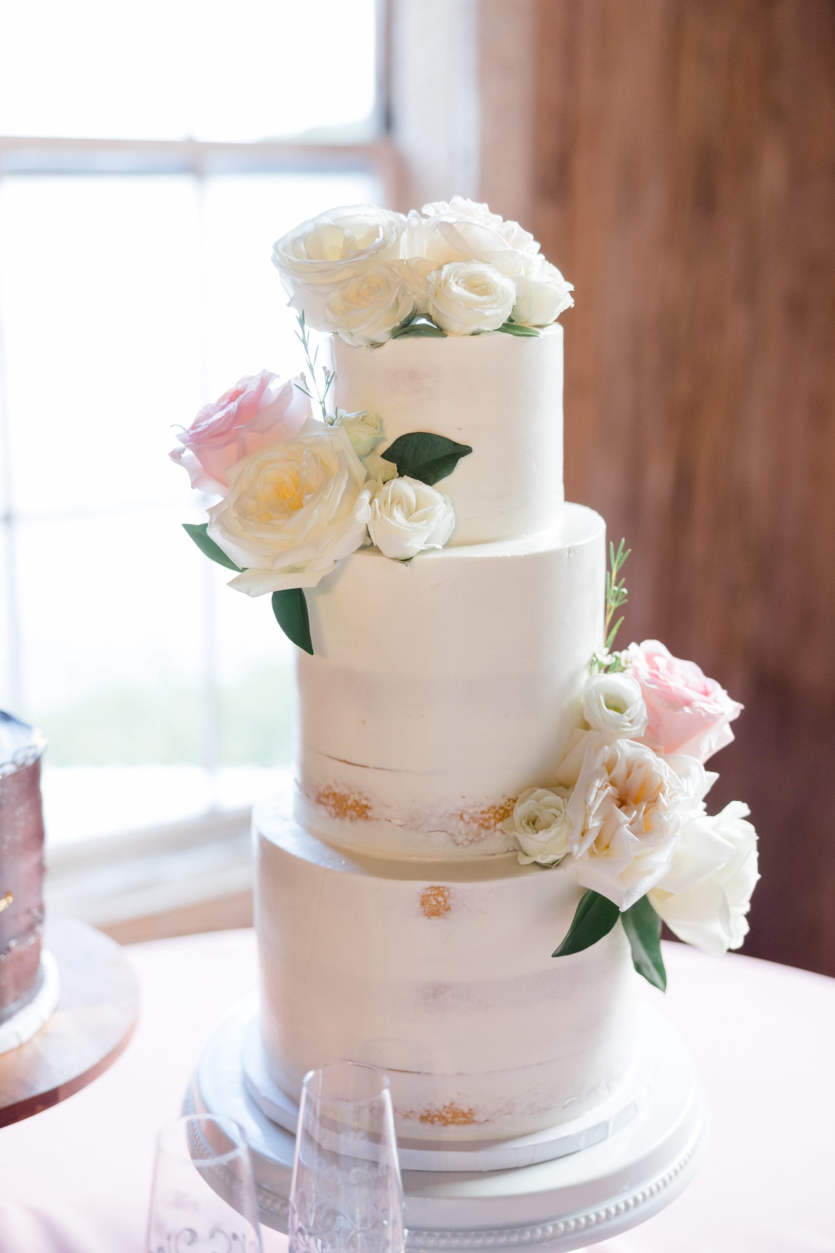 tiered wedding cake with pink and white accents