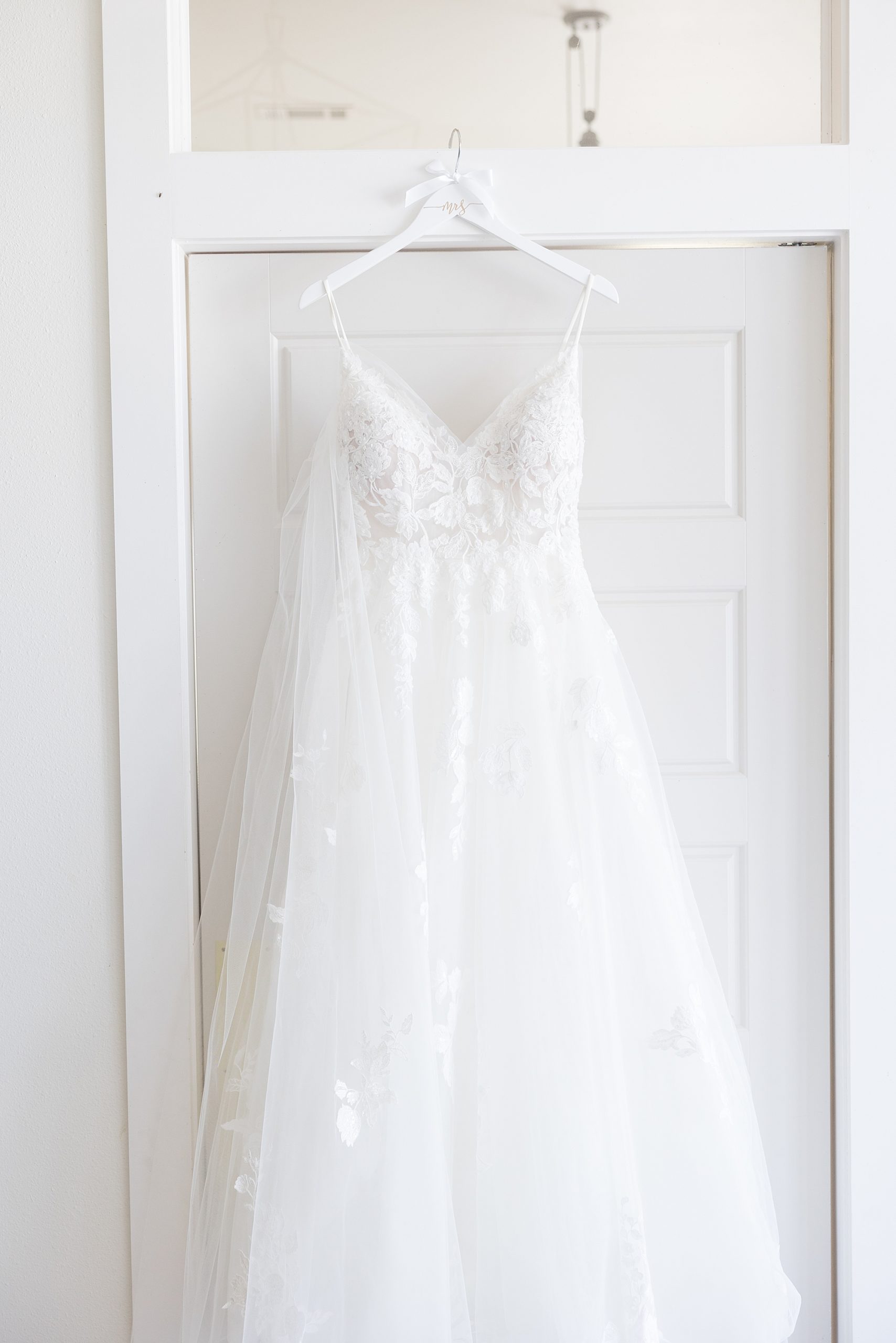 wedding dress hangs in suite at Oak + Ivy