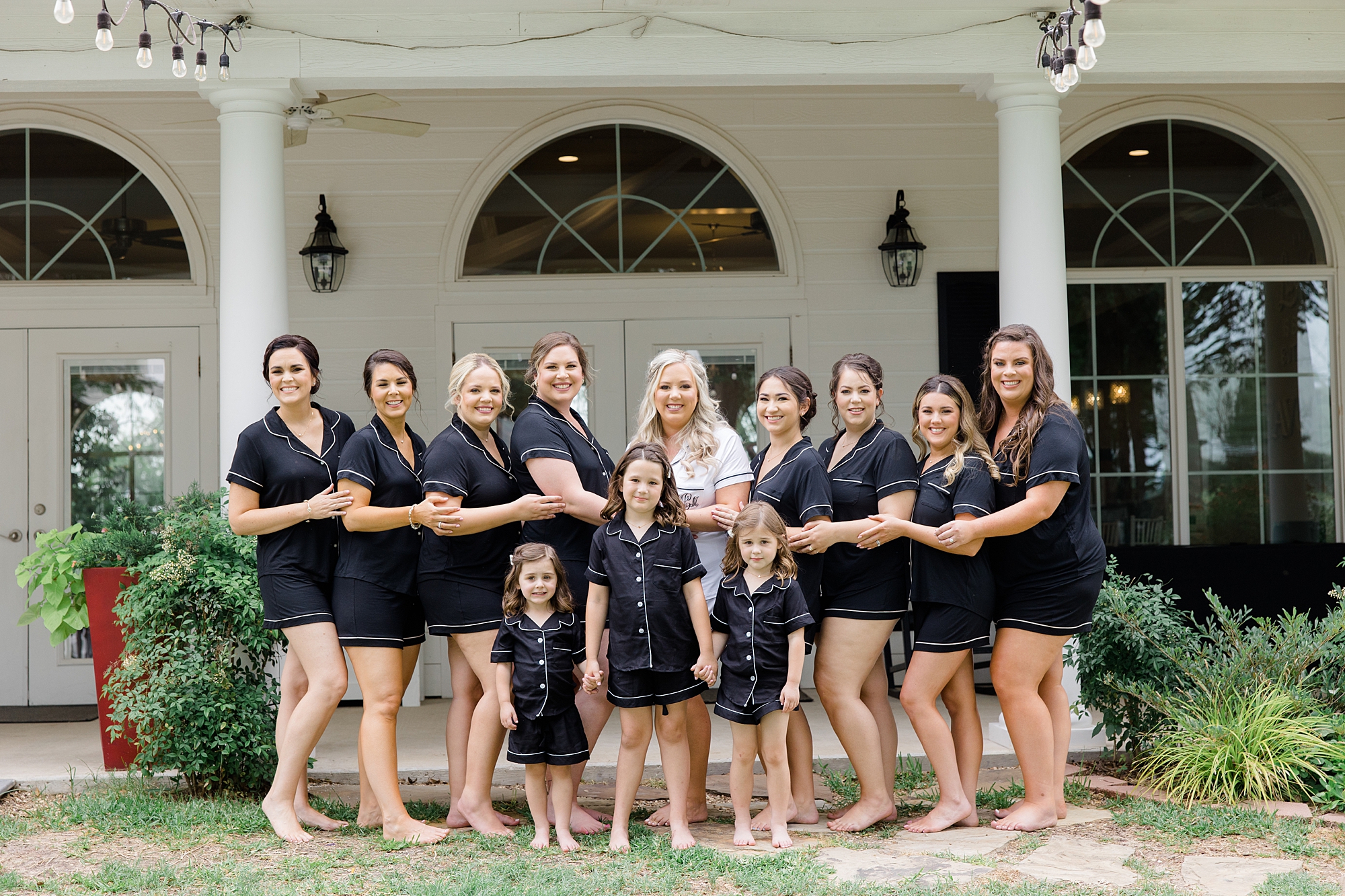 bride poses with bridesmaids in matching robes outside Willow Creek