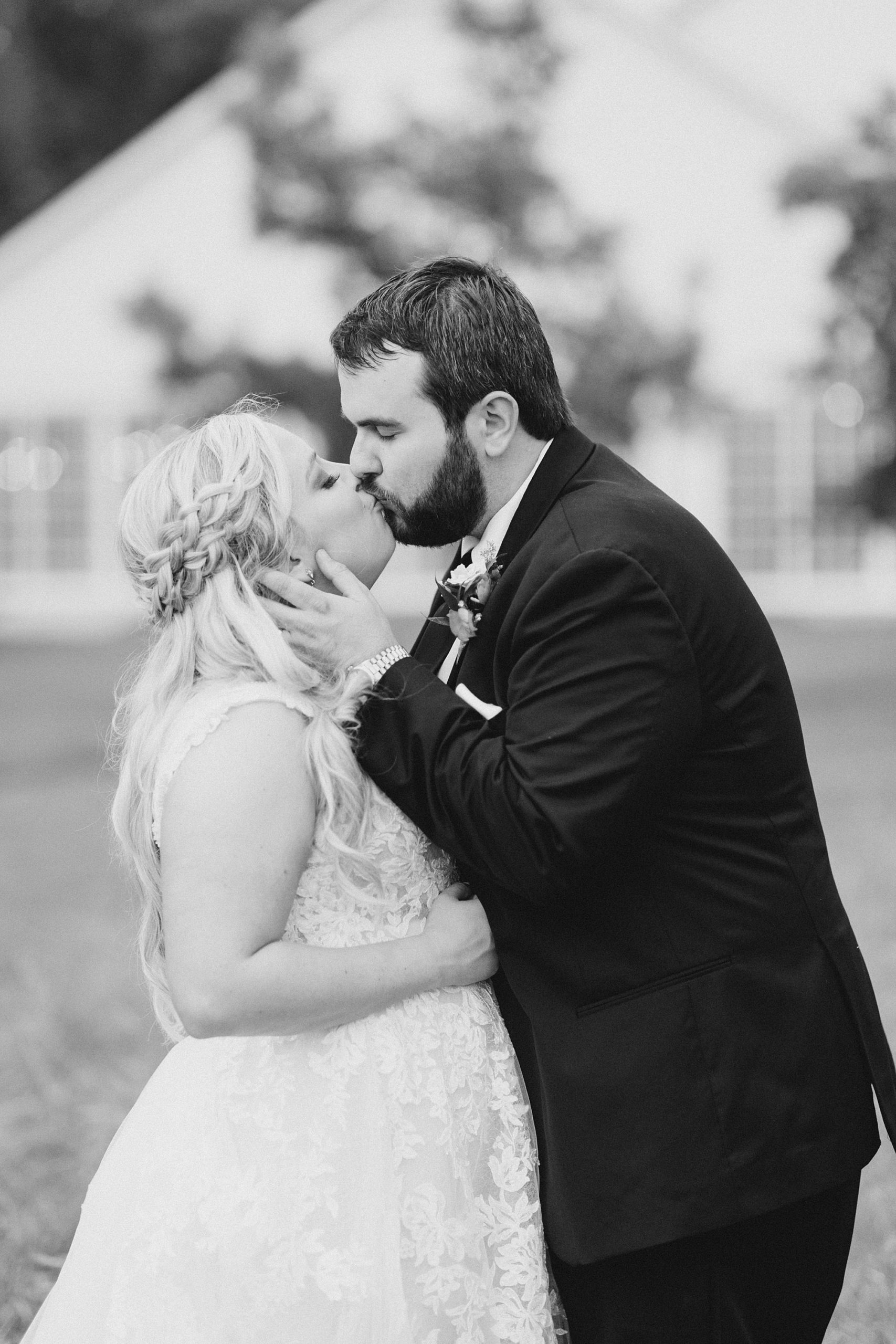 husband and wife kiss during wedding photos