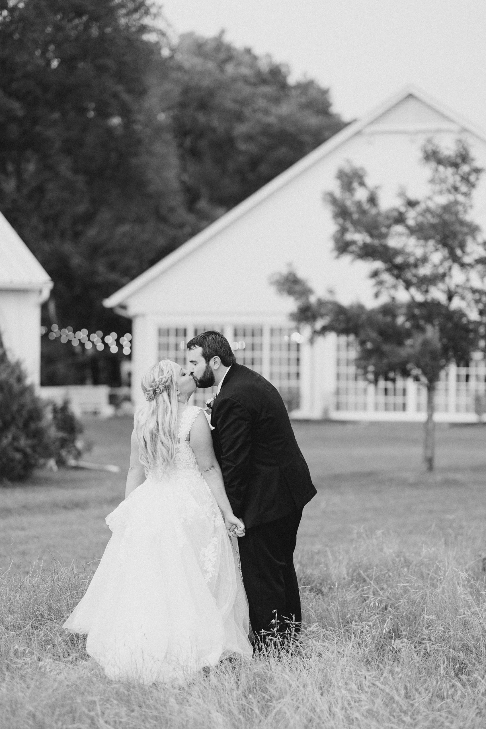 groom leans to kiss bride during portraits at Willow Creek