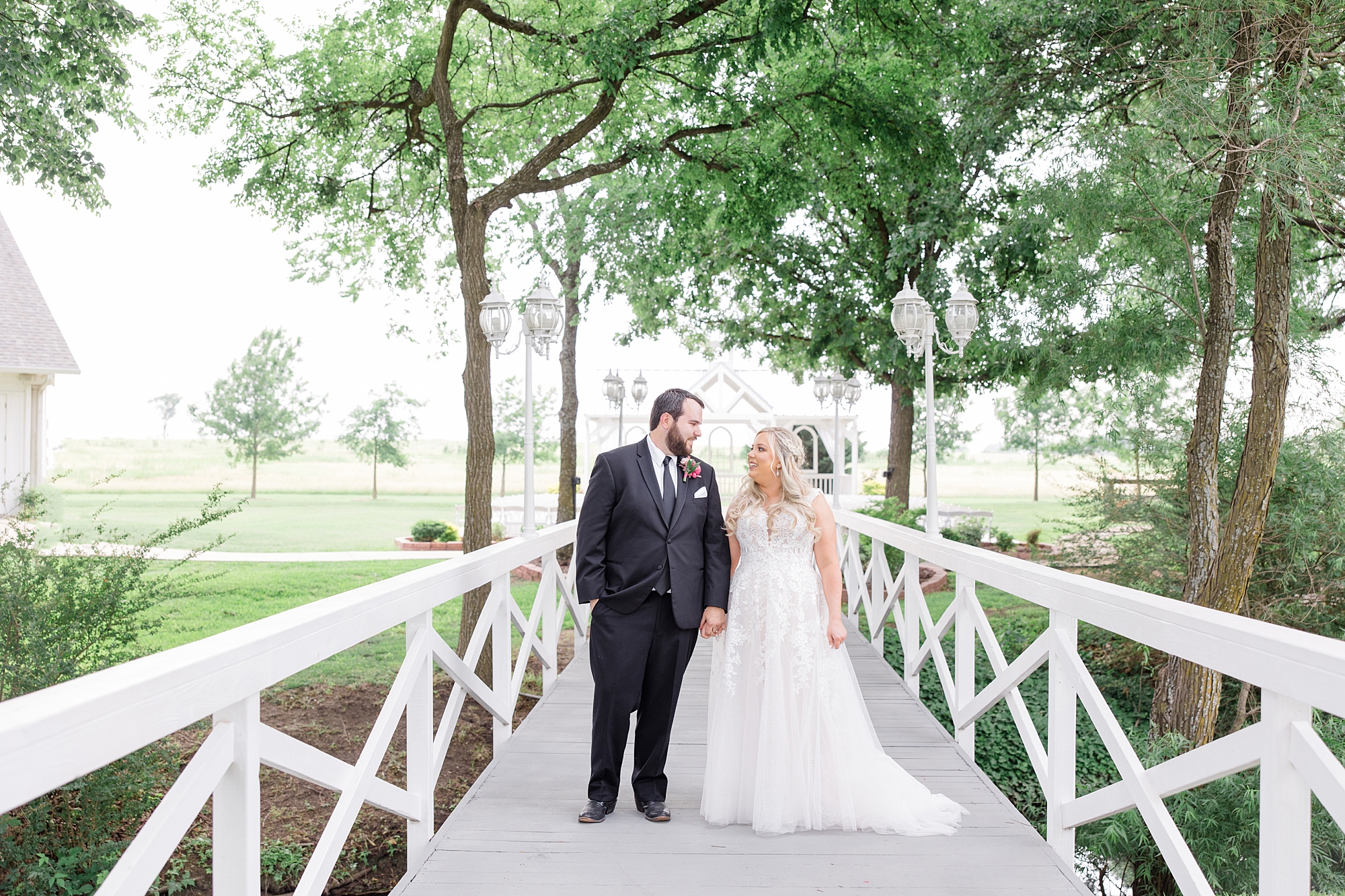 bride and groom hold hands on bridge at Willow Creek