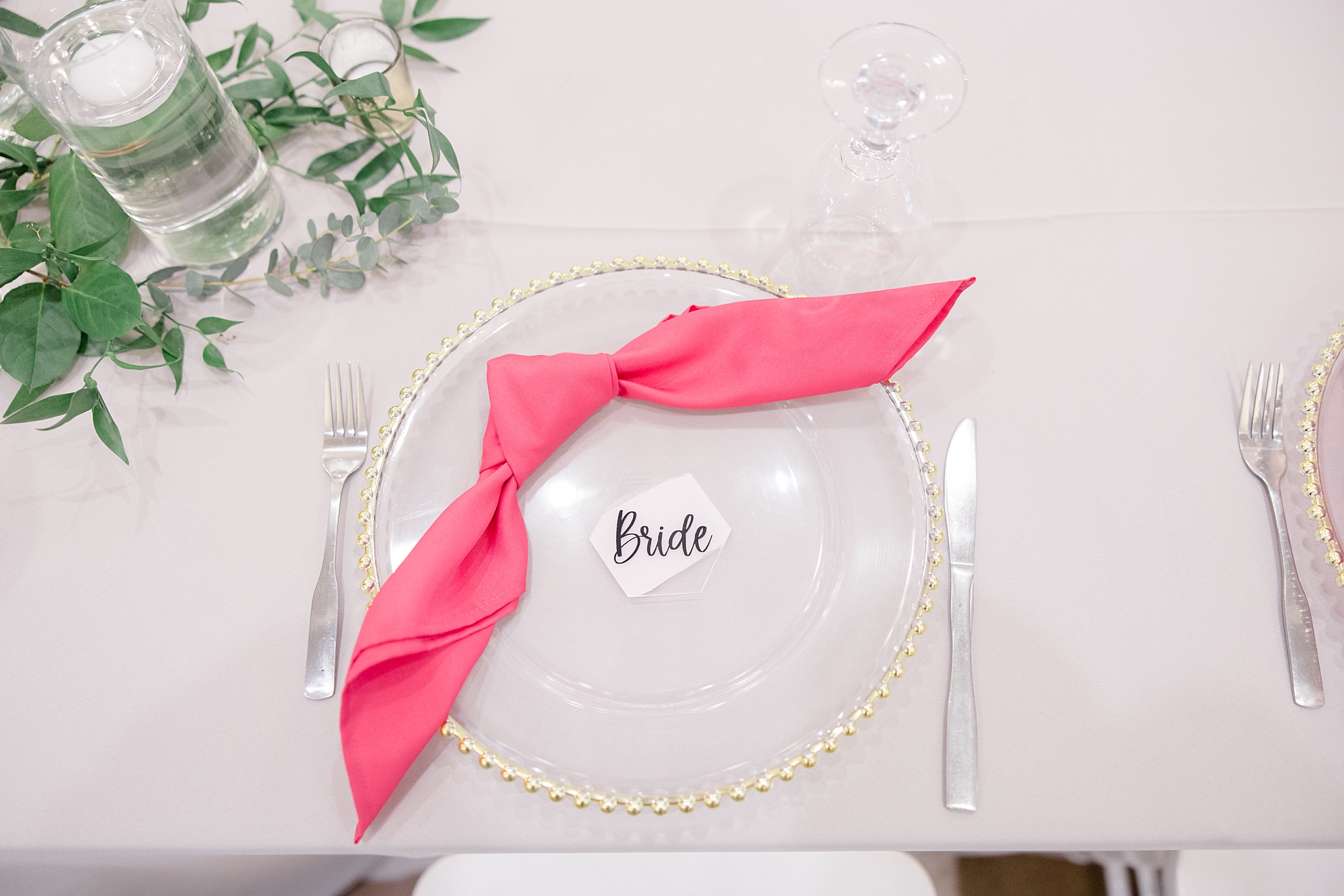 place setting with pink napkin and gold rimmed plate