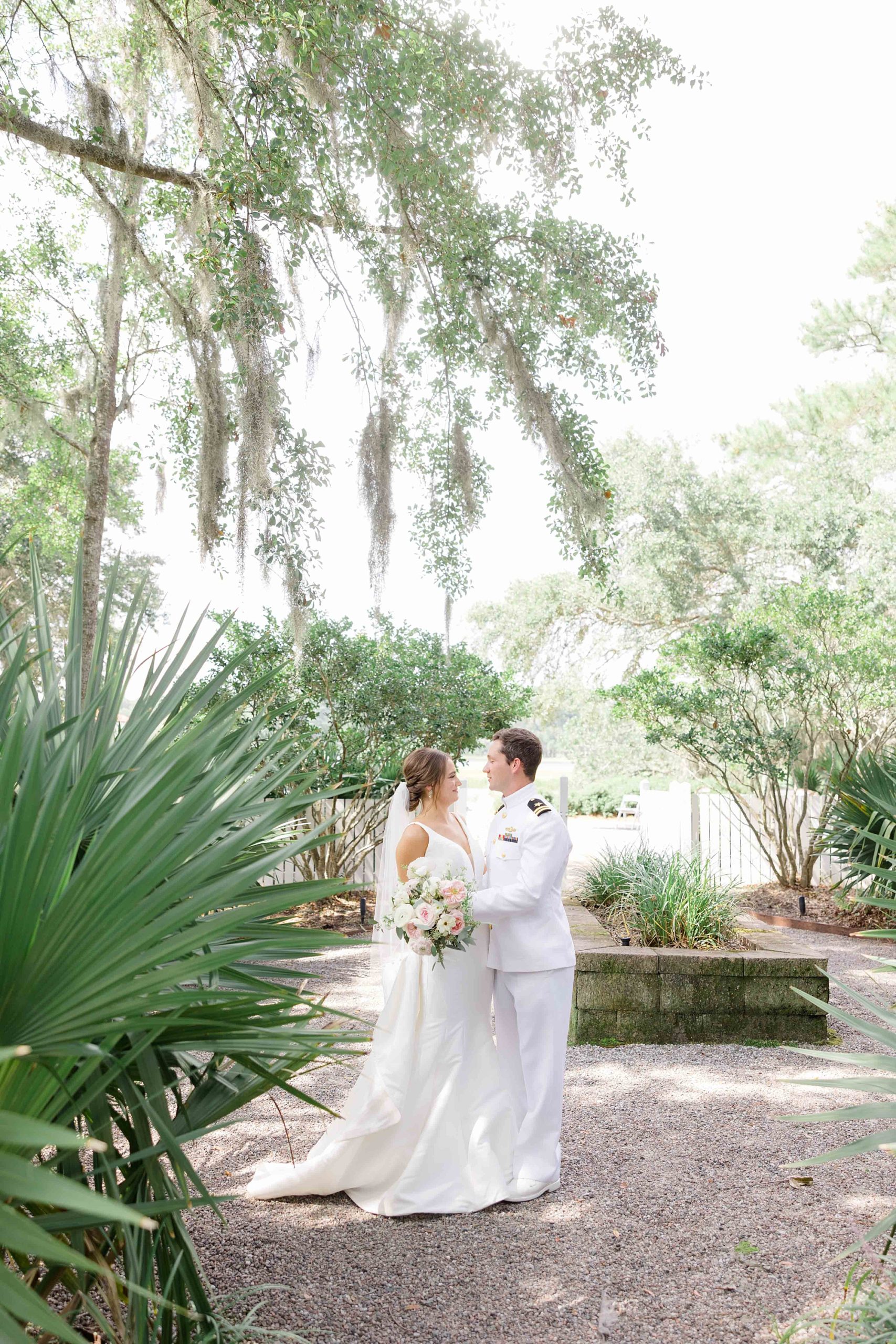 bride and groom smile together in garden at Club Creek at Ion in Charleston SC