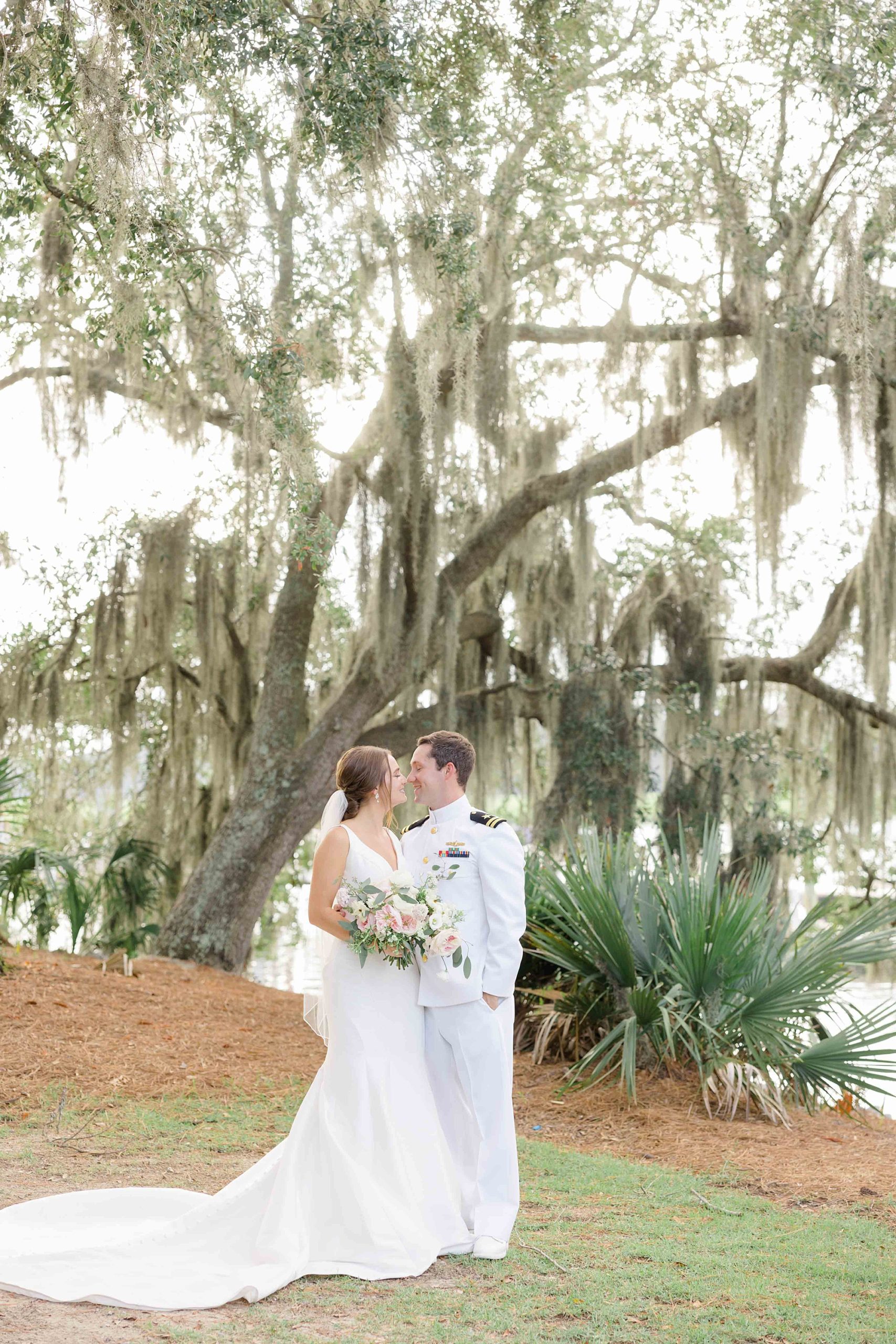 newlyweds pose together by Spanish moss in Charleston SC