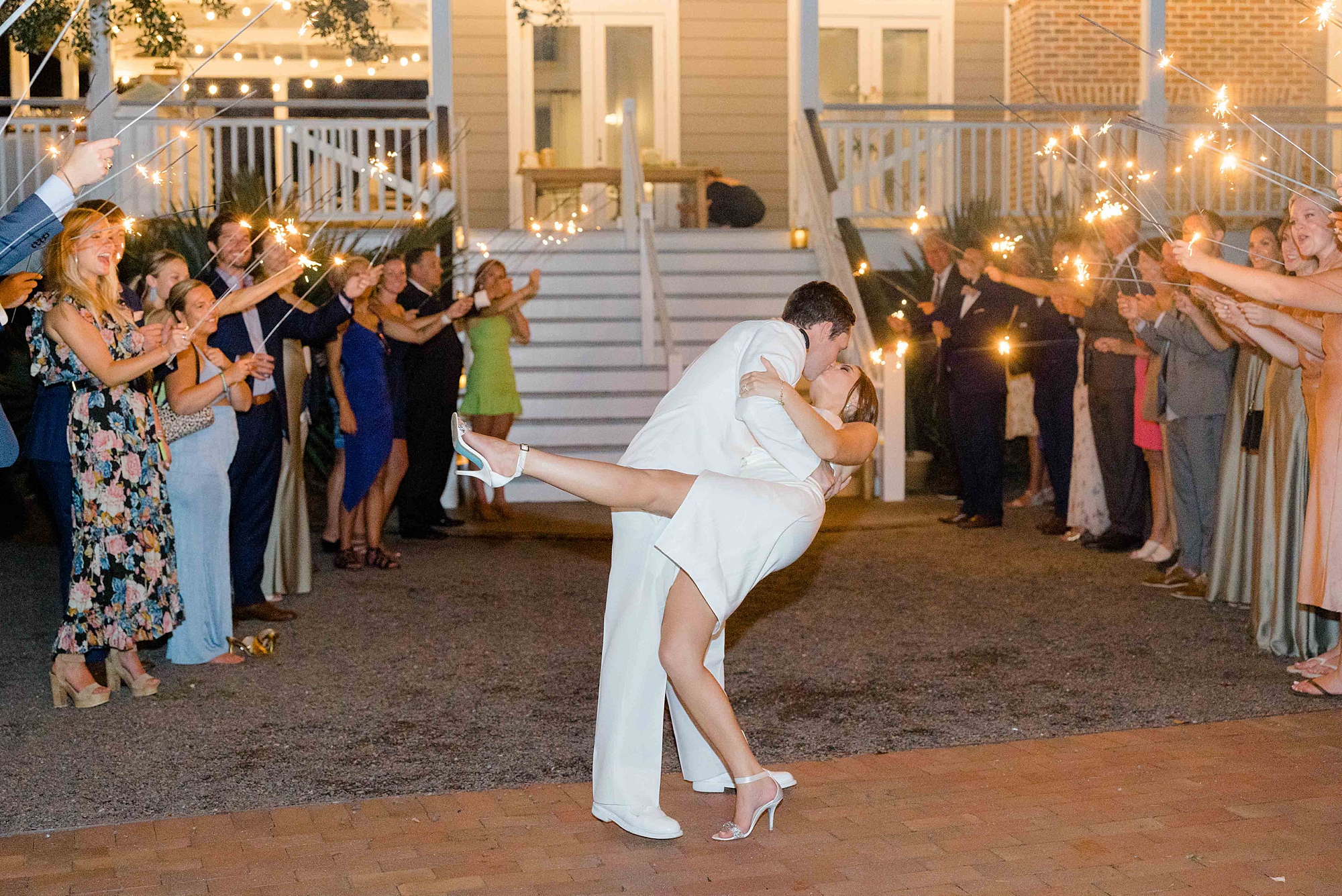 groom dips bride kissing her during sparkler exit