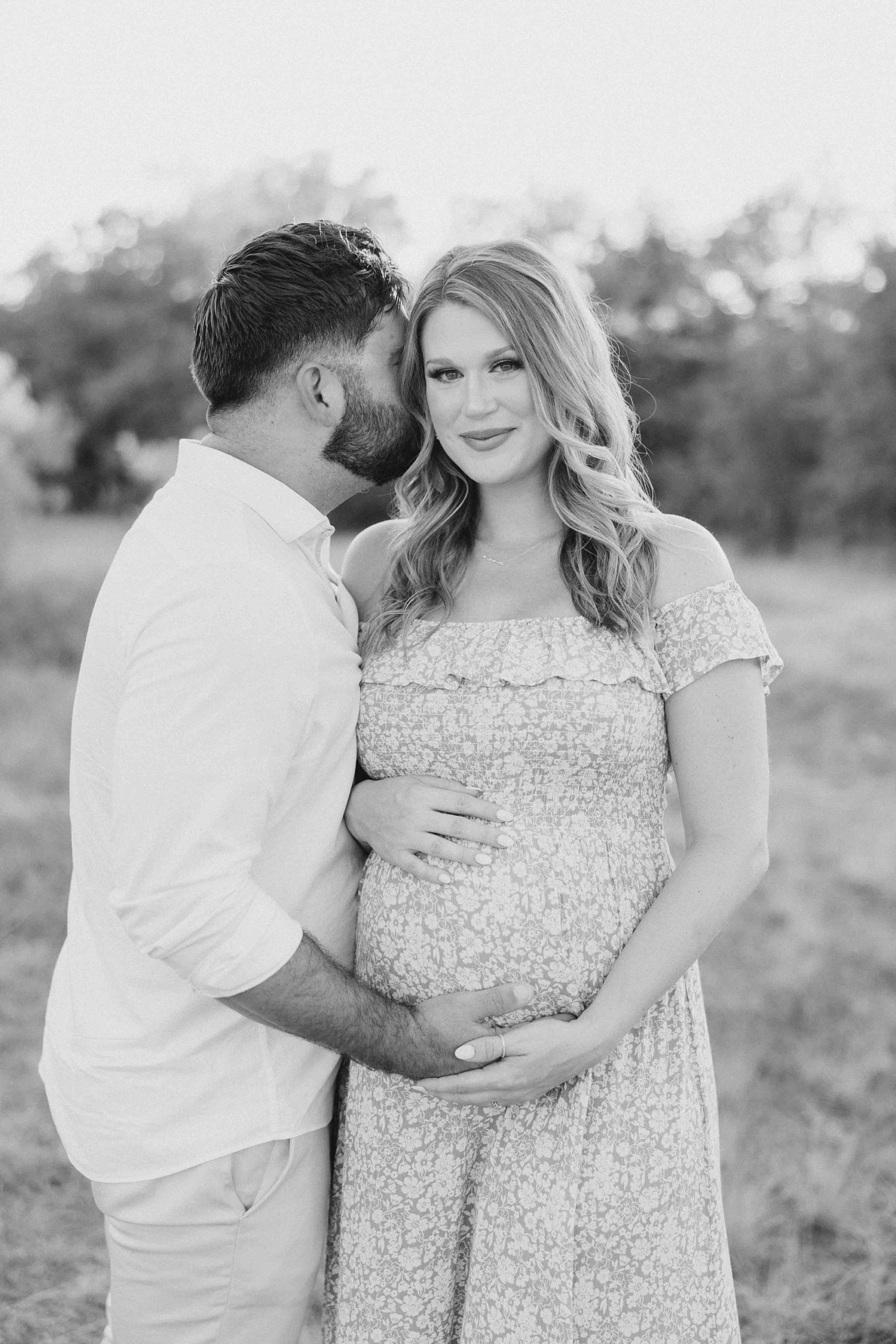 man kisses wife's cheek during Murrell Park maternity session