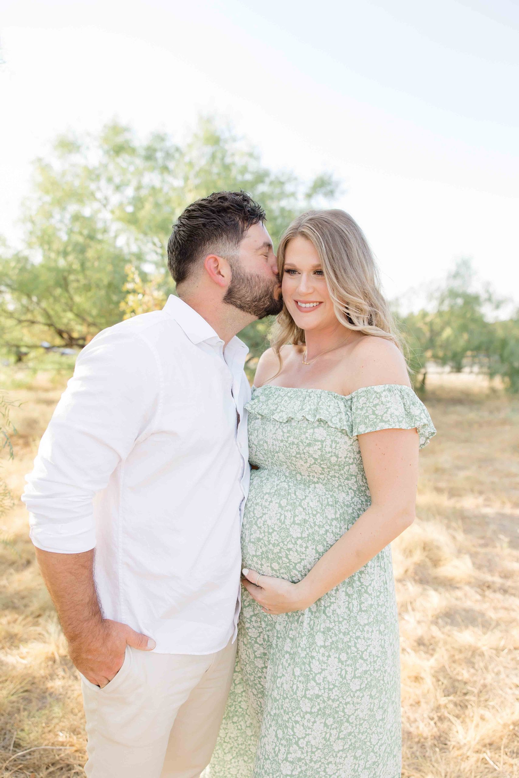 man kisses wife during Murrell Park maternity session