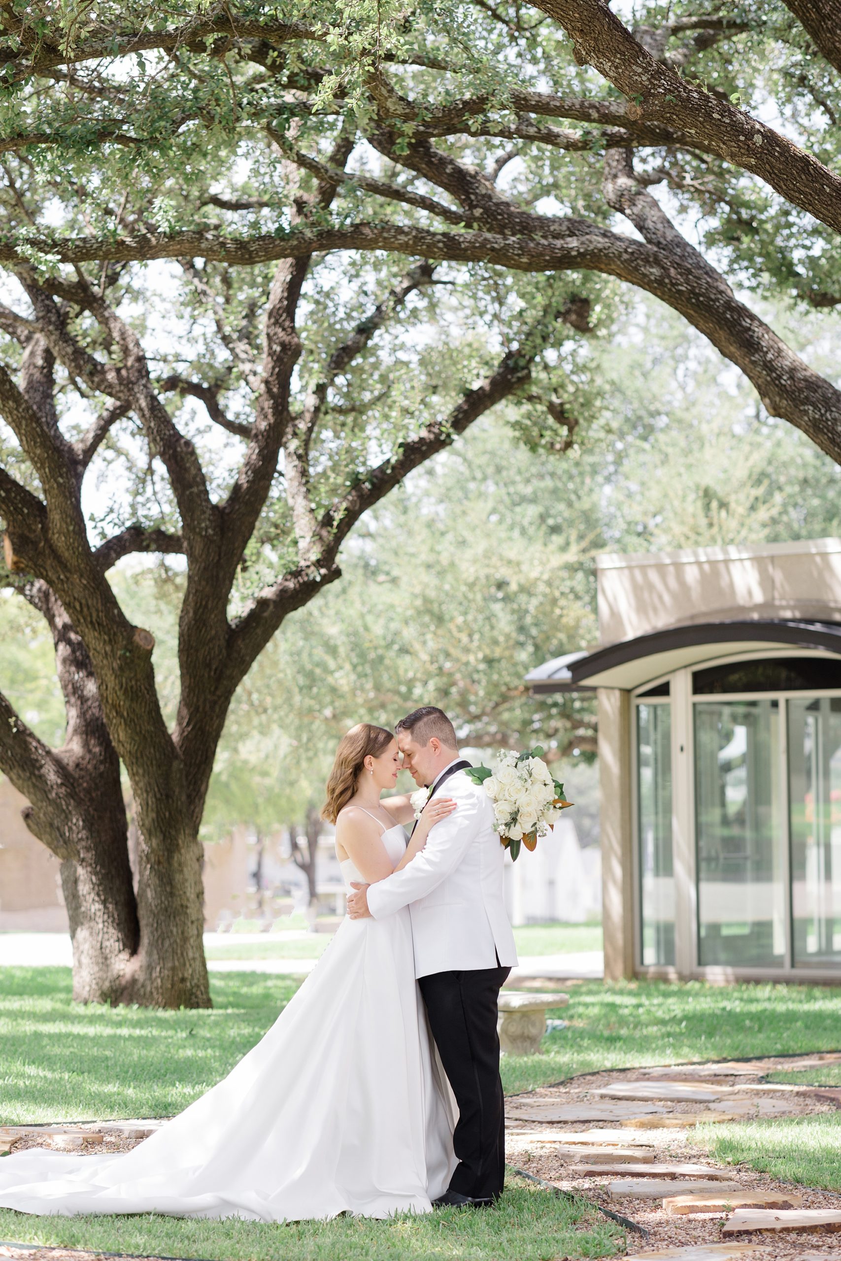 bride and groom hug touching heads under trees in Fort Worth TX