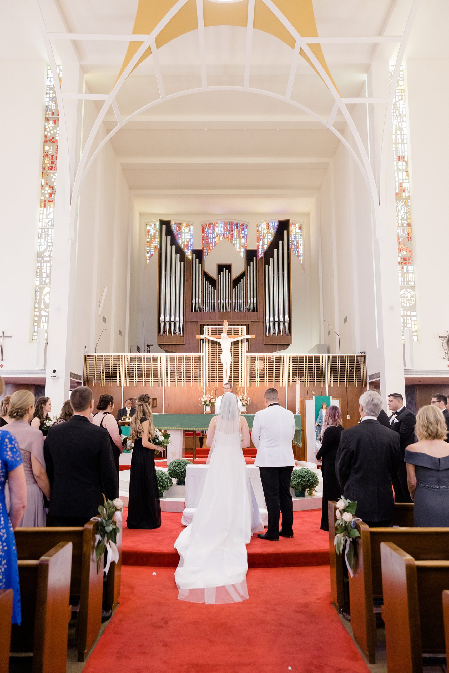 bride and groom stand at alter together in the Holy Family Catholic Church
