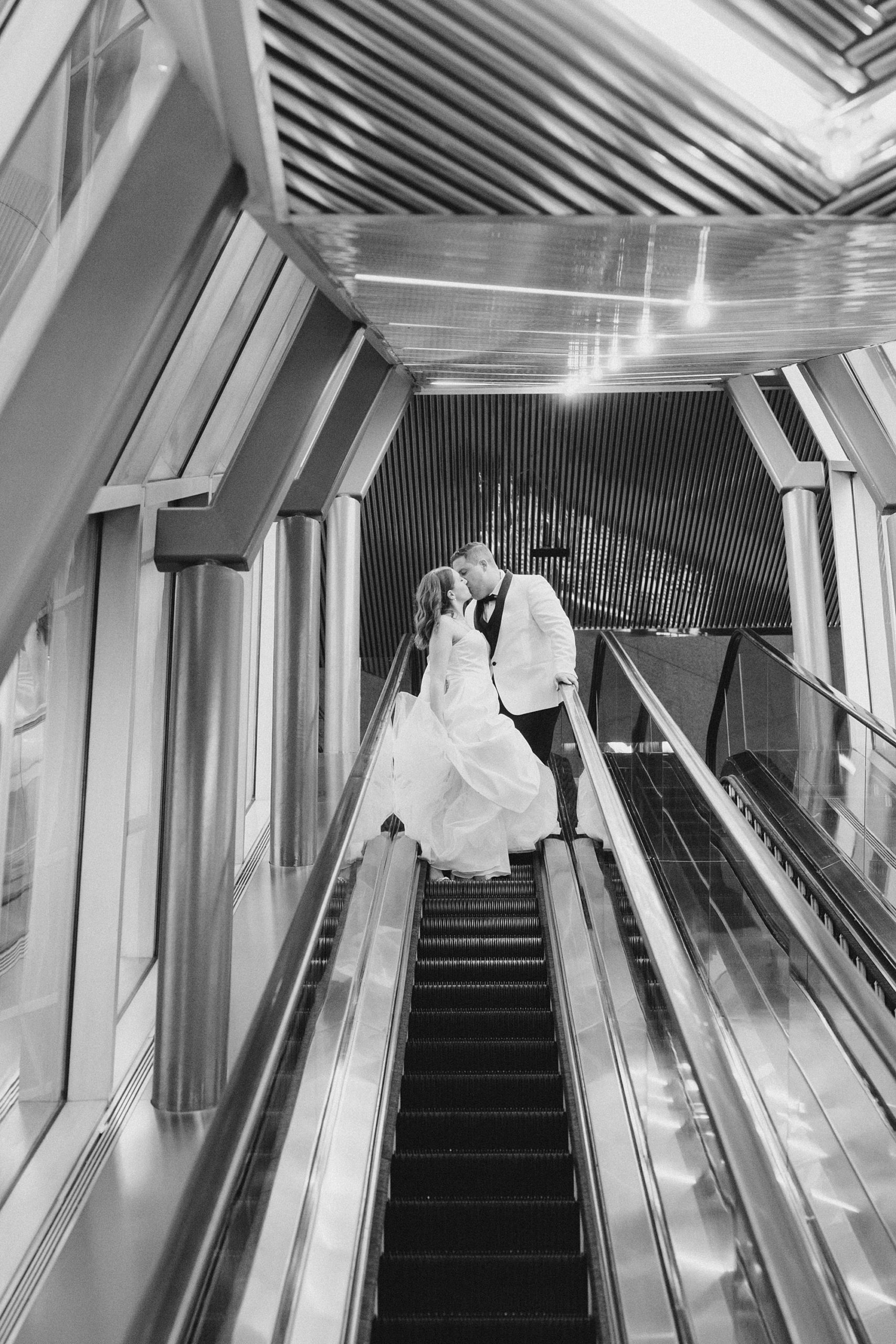 bride and groom kiss on escalator in Fort Worth 
