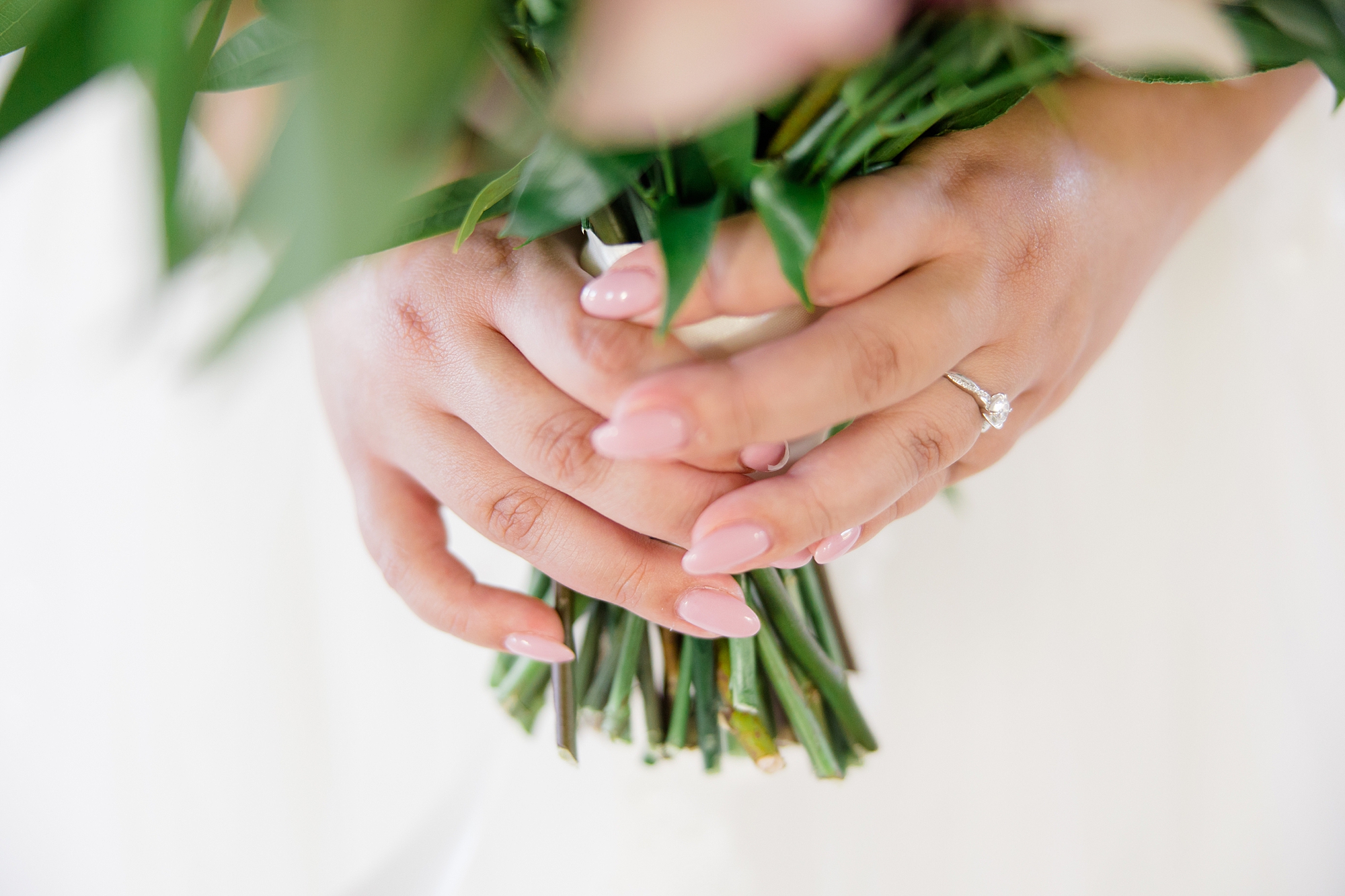 bride holds bouquet showing off engagement ring 