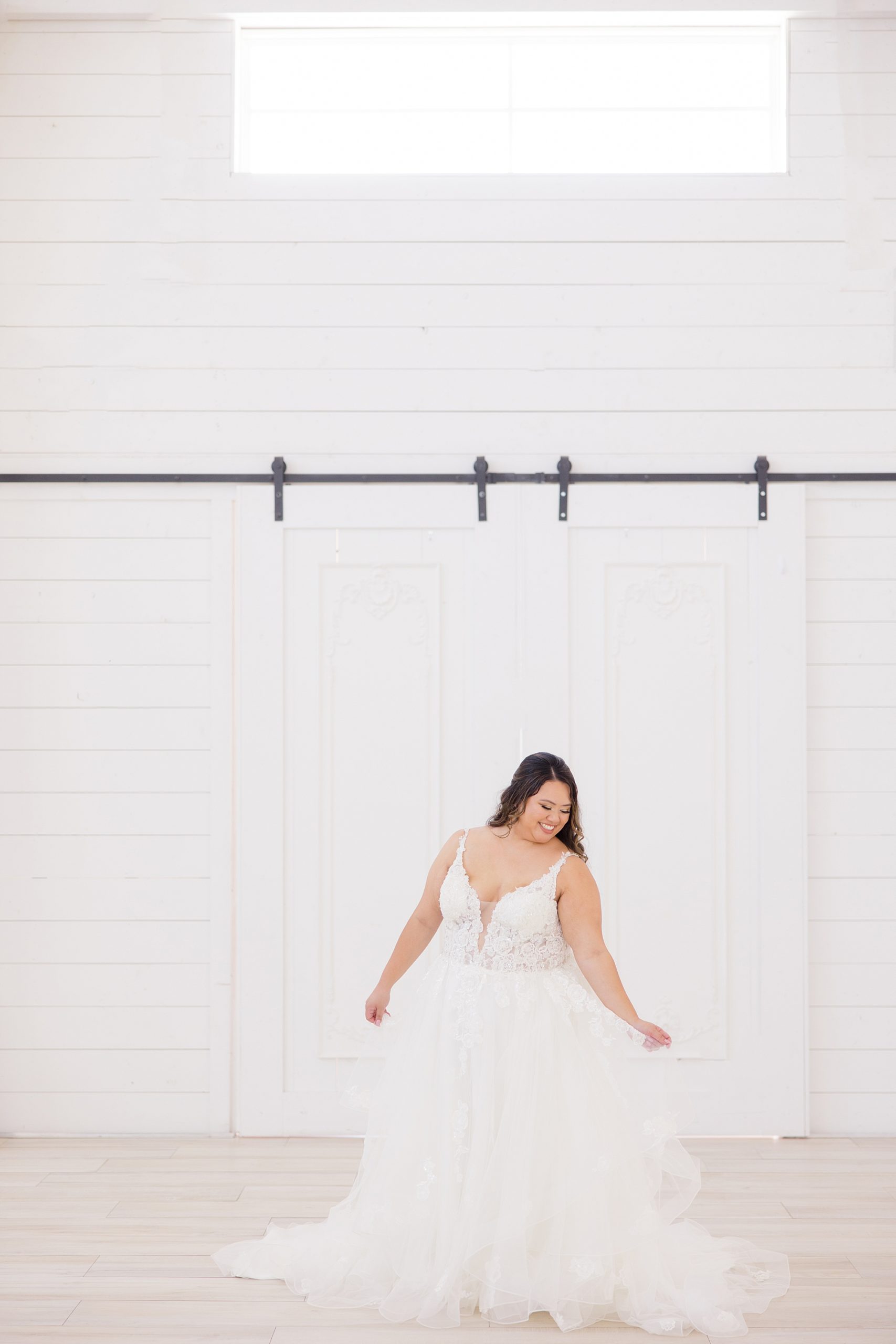 bride twirls wedding gown in front of wooden door at The Nest at Ruth Farms