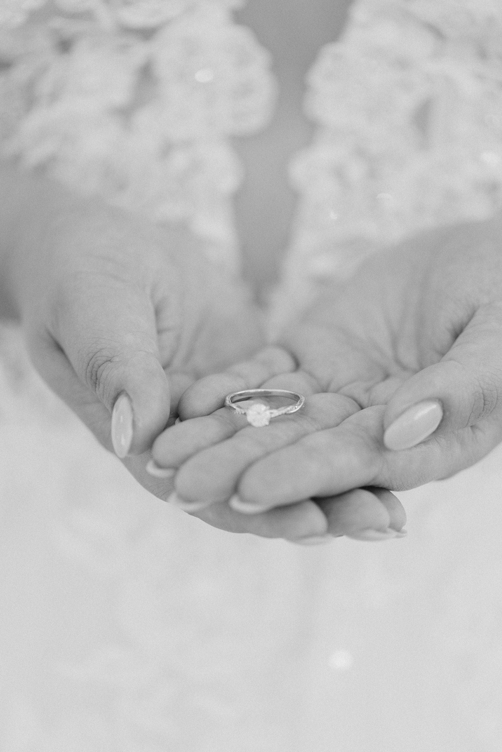 bride holds engagement ring in hands 