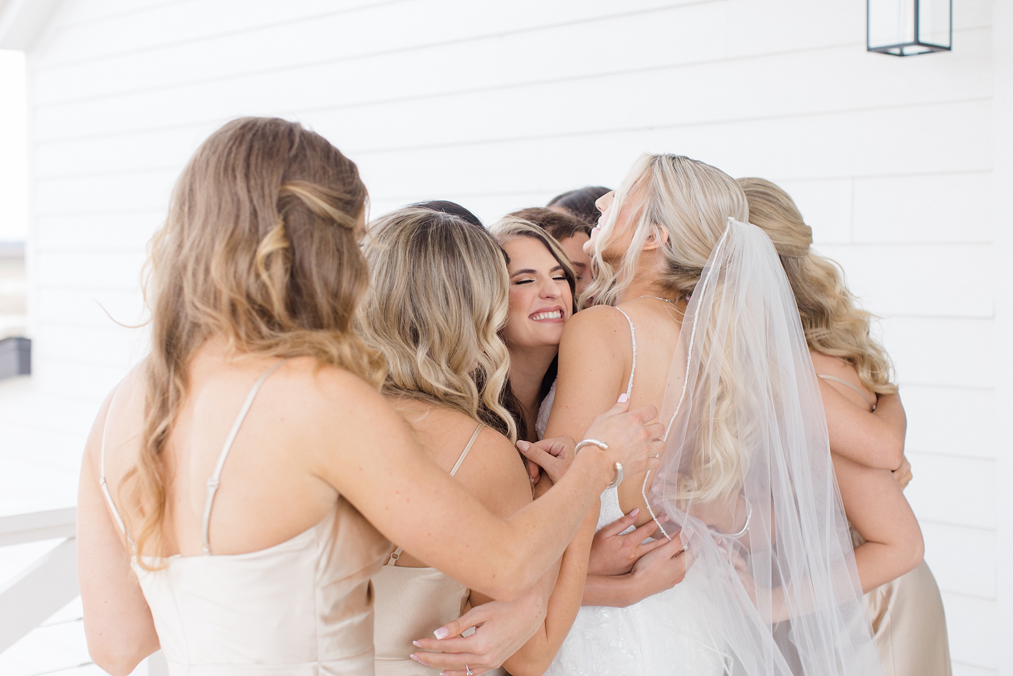 bridesmaids hug bride during first look 