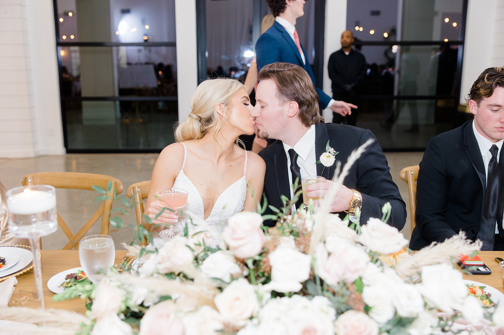 bride and groom kiss at head of table 