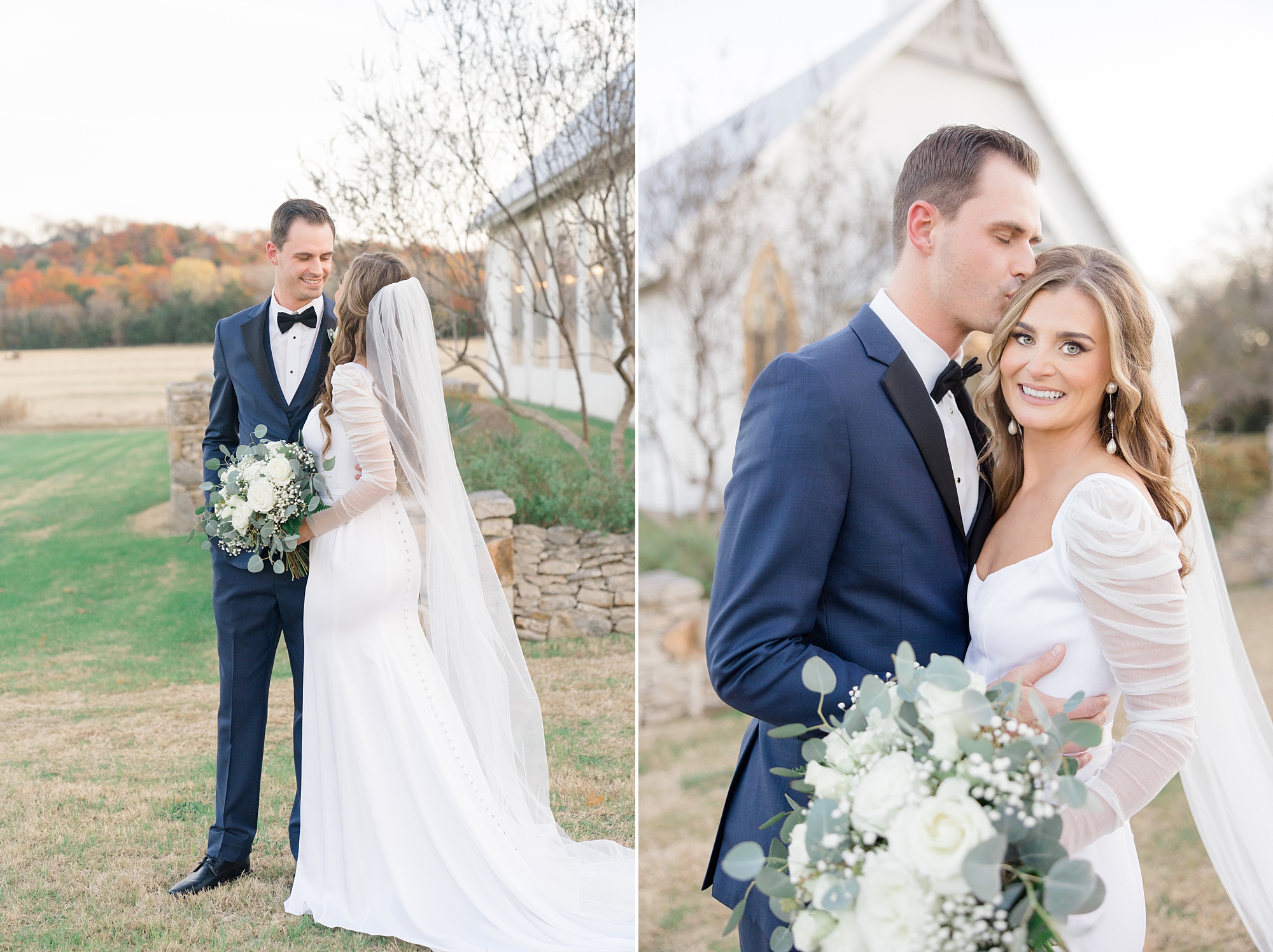 groom in navy suit kisses bride's forehead while she holds bouquet of white flowers 