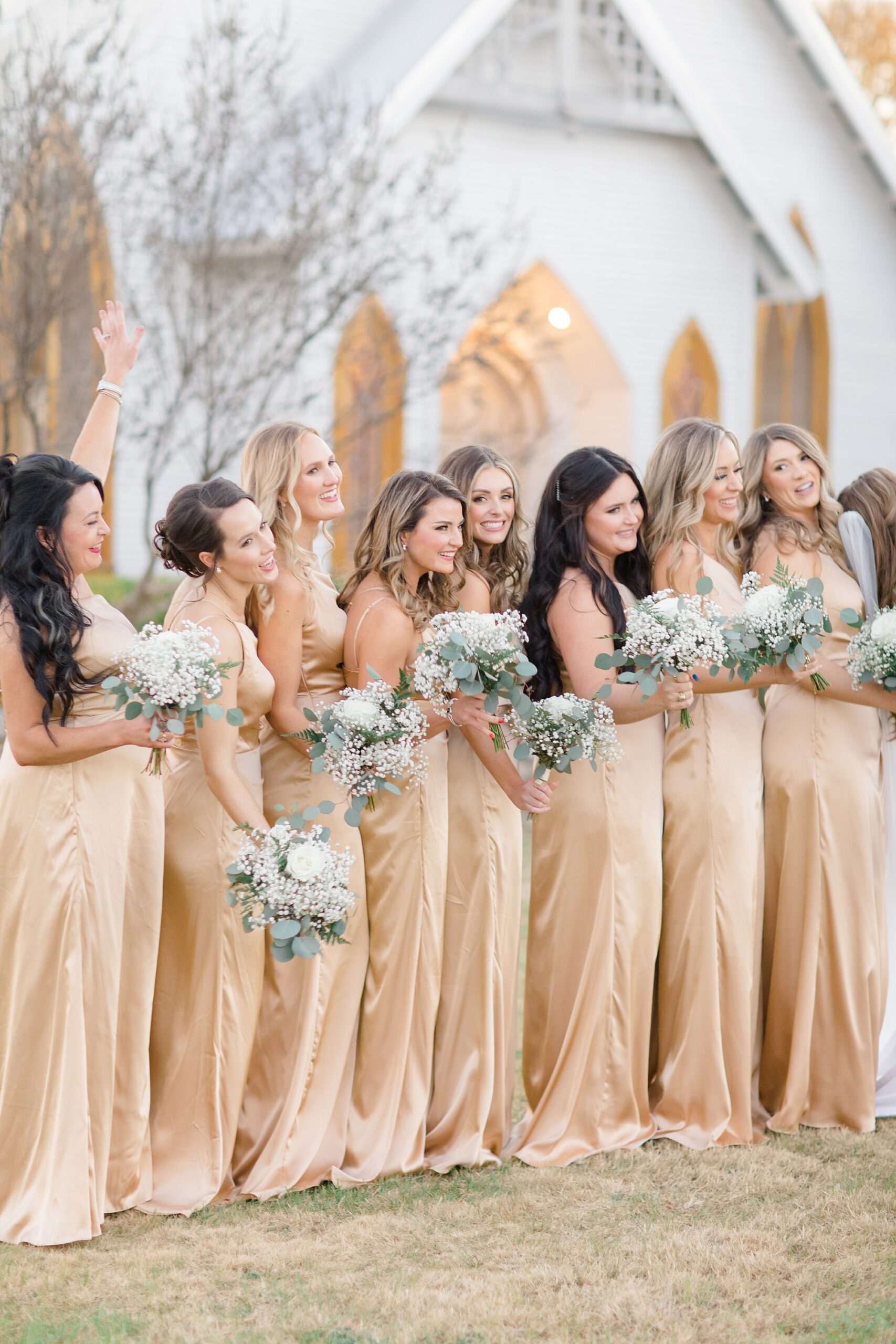 bridesmaids smile during portrait outside white chapel 