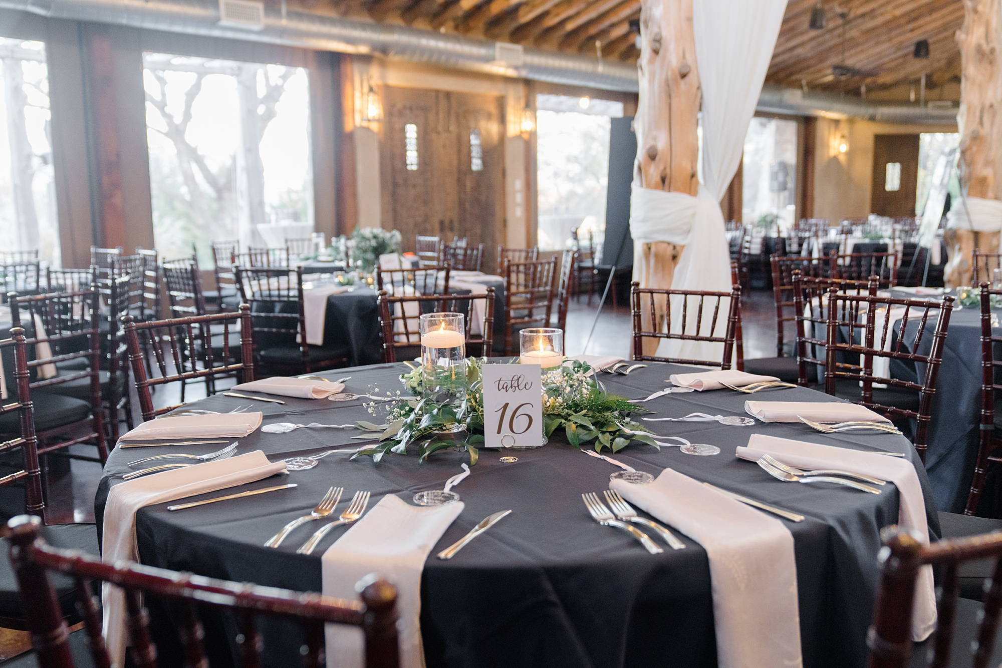 wedding reception with black table cloth and pink napkins 
