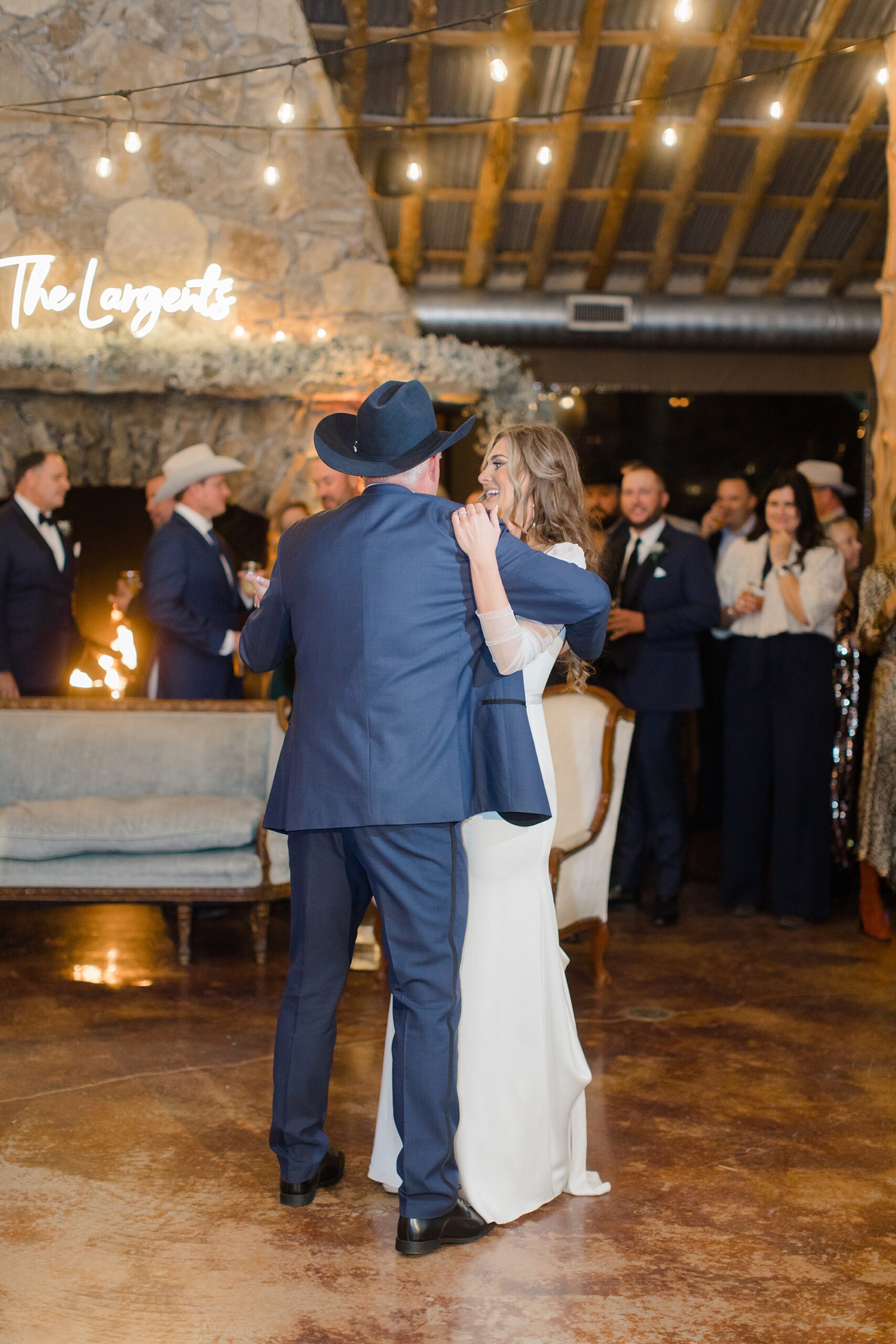 bride hugs father in cowboy hat on dance floor 
