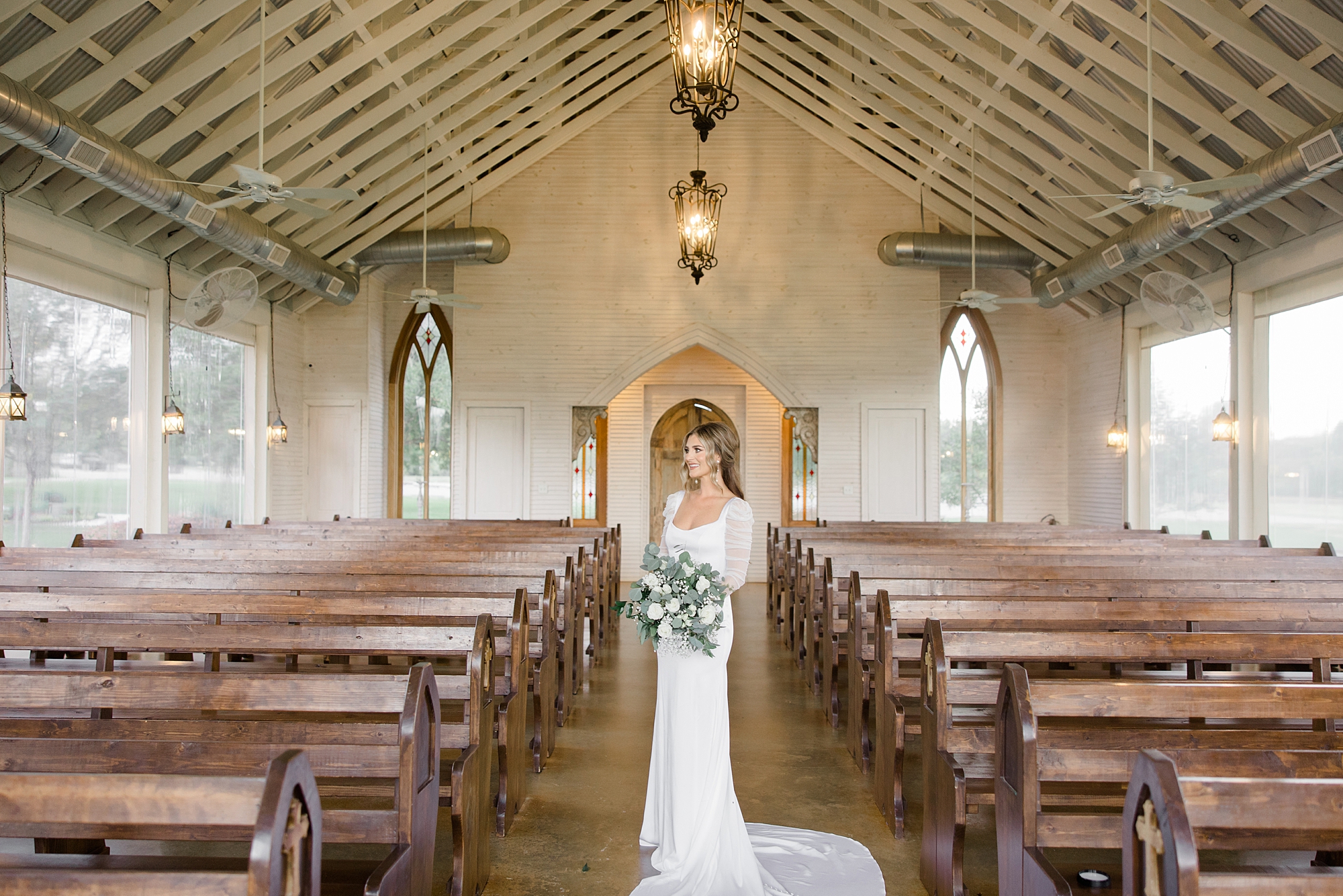 bride stands between pews at The Brooks at Weatherford