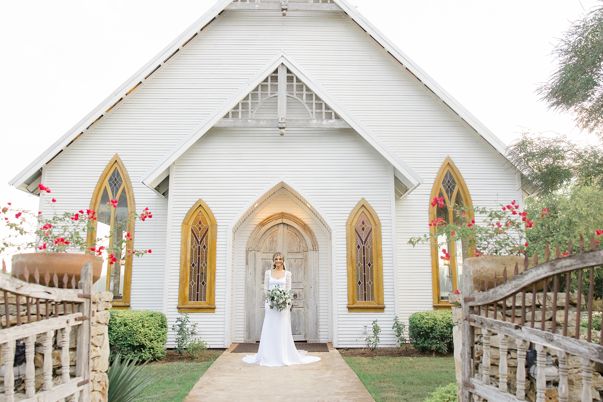 bride stands outside white chapel in Texas