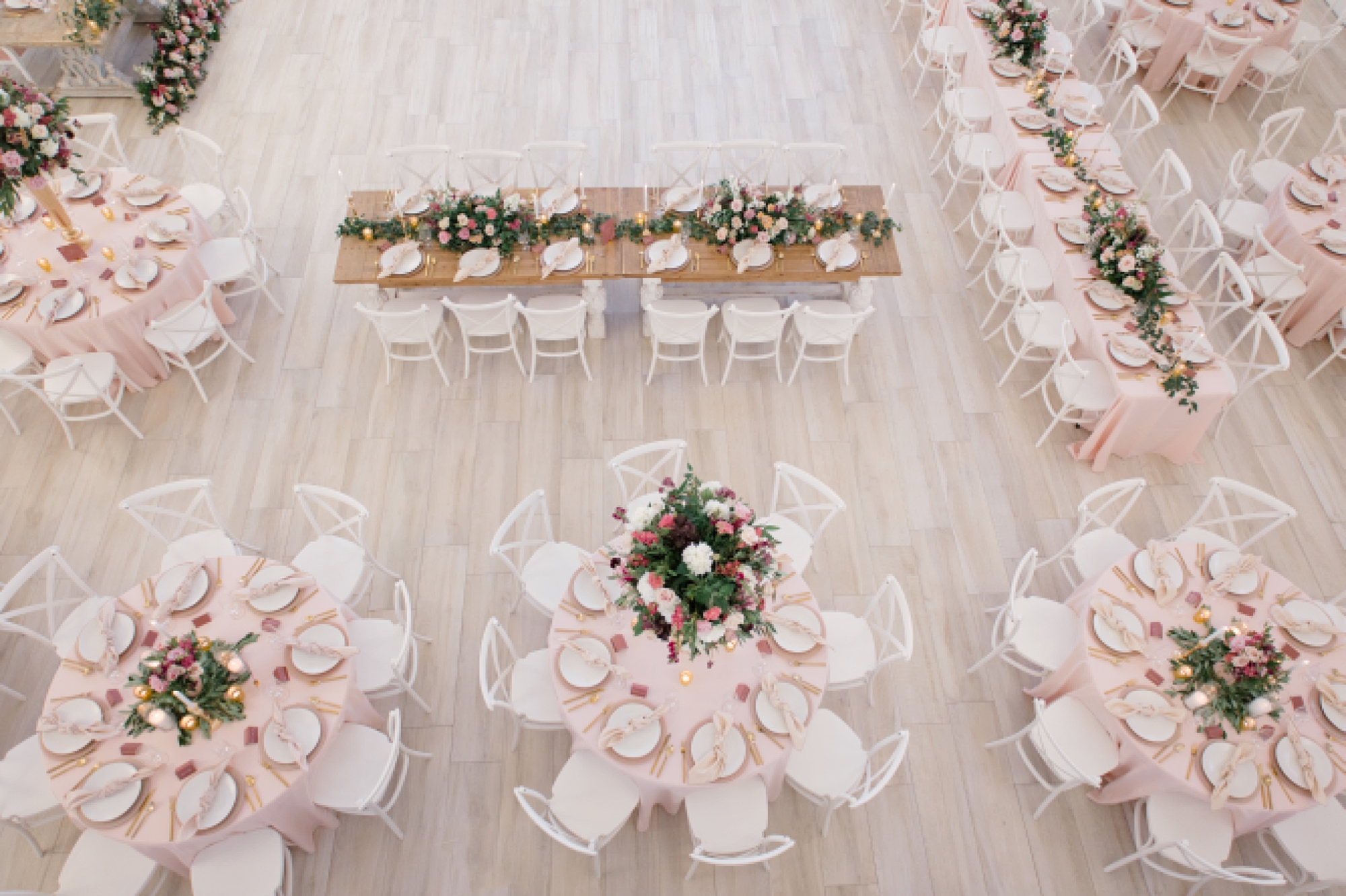 wedding reception with pink napkins and floral centerpieces from above 