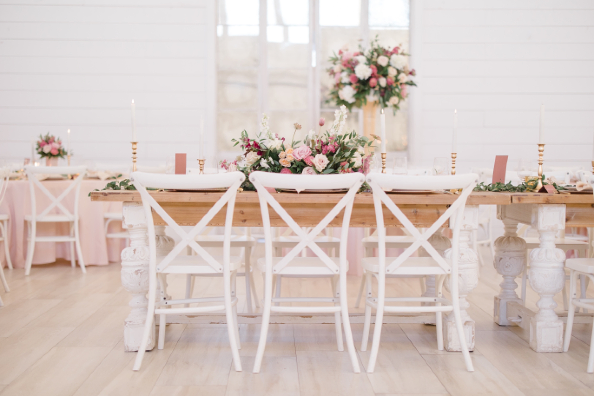 family style table with tall pink and white floral centerpiece for winter Nest at Ruth Farms wedding reception 