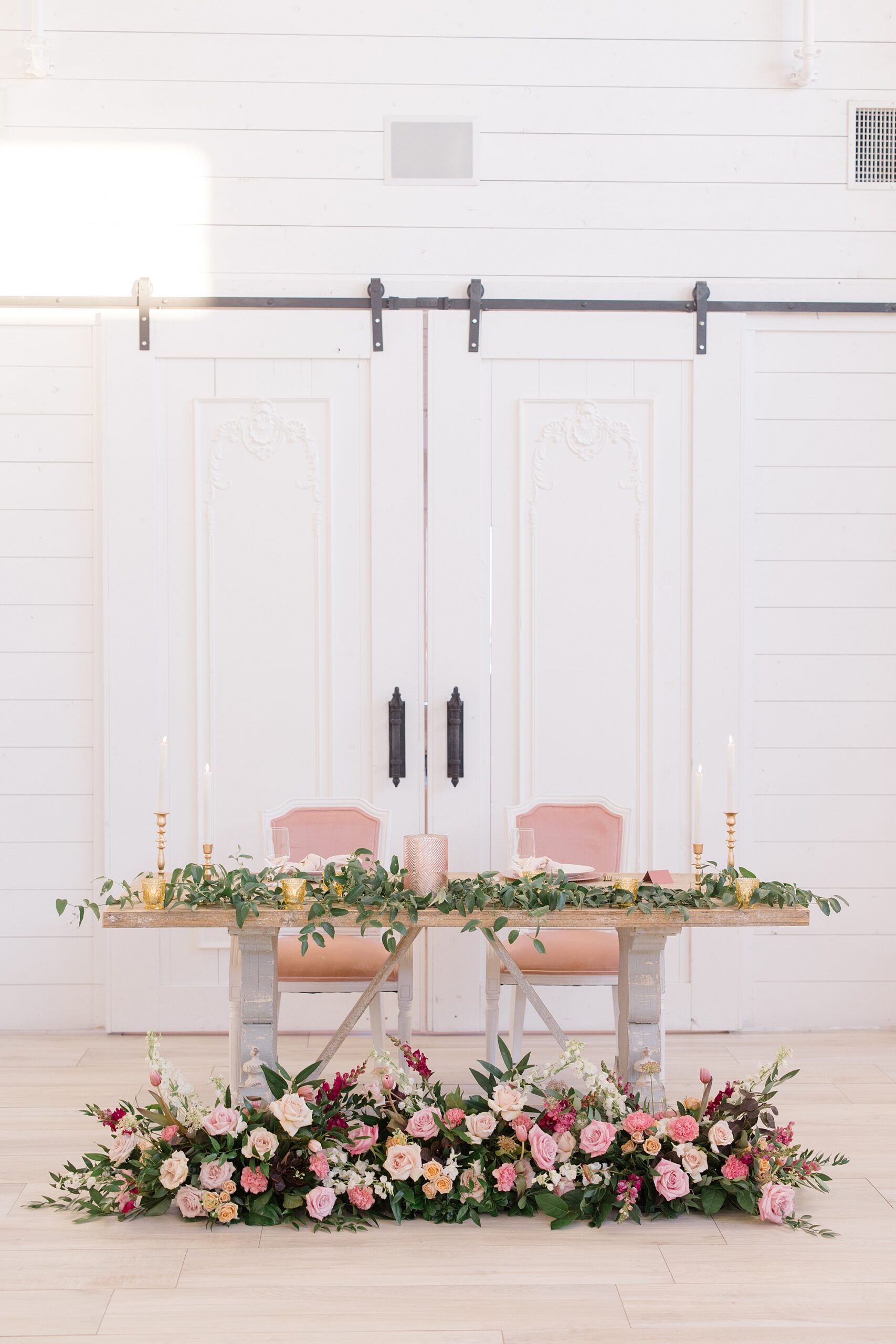 sweetheart table by sliding wood doors at The Nest at Ruth Farms 
