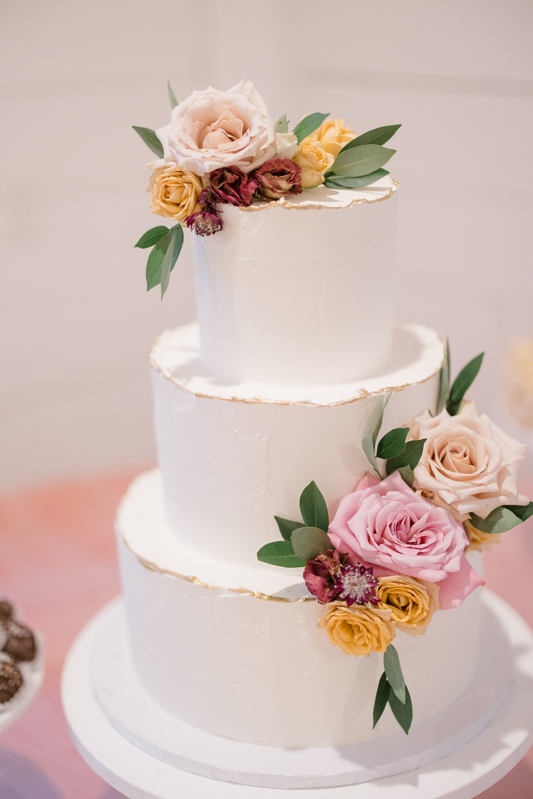 tiered wedding cake with pink rose accents 