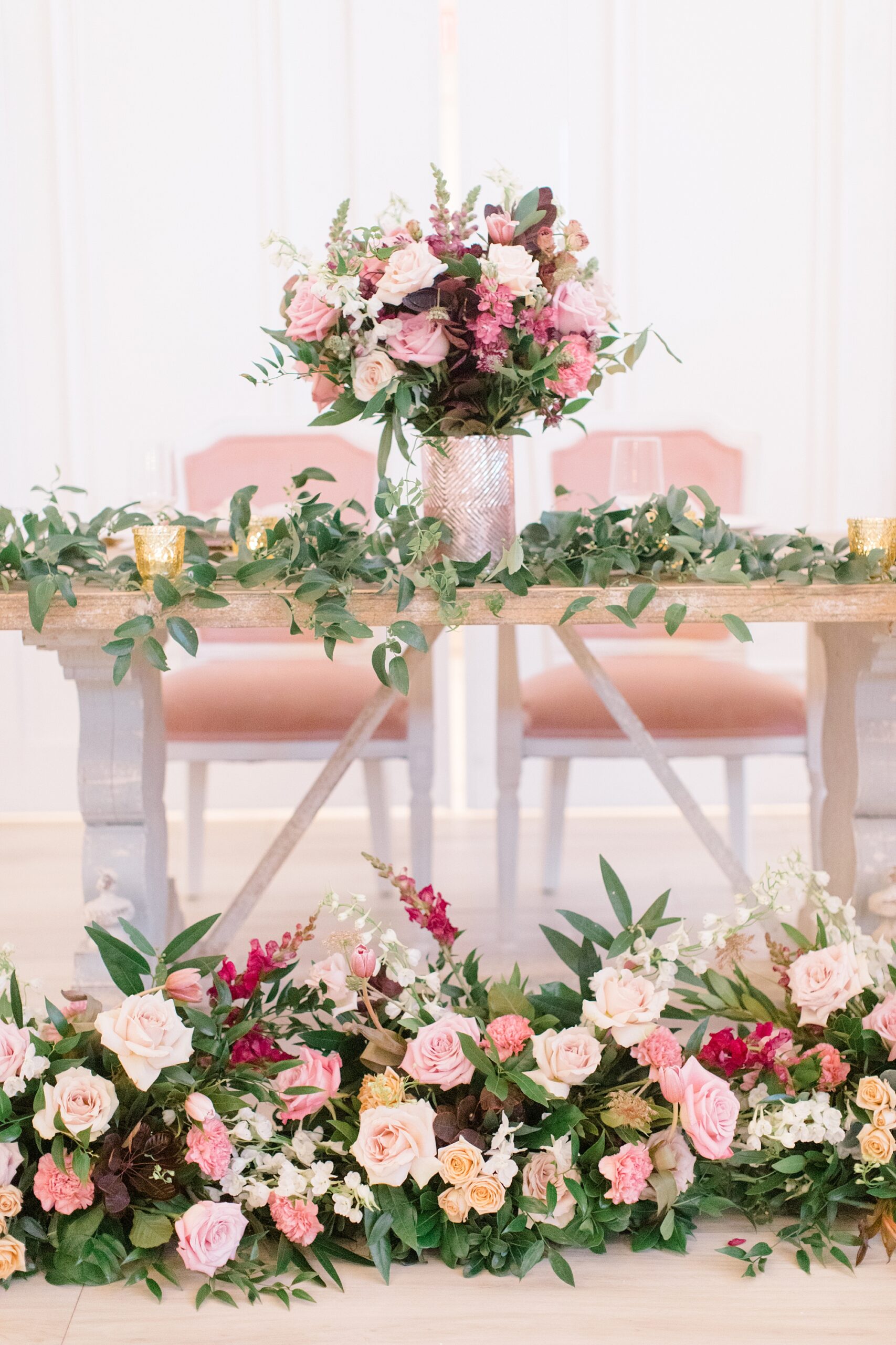 sweetheart table with florals in front and across top at winter Nest at Ruth Farms wedding reception 