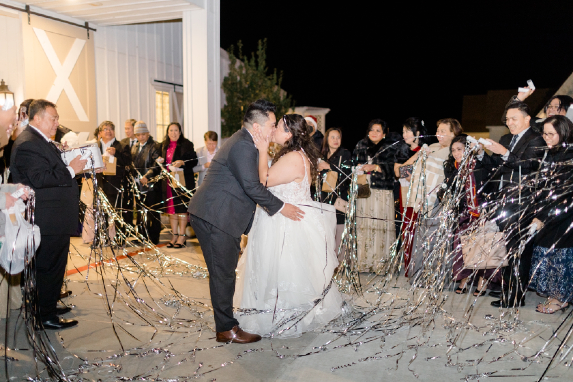 newlyweds walk through ribbon exit from Nest at Ruth Farms wedding reception