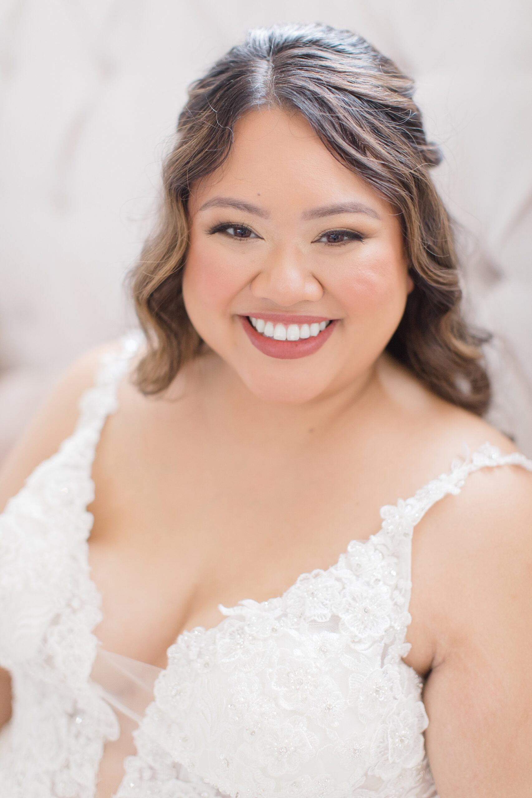 bride smiles sitting in wedding dress with v-neck
