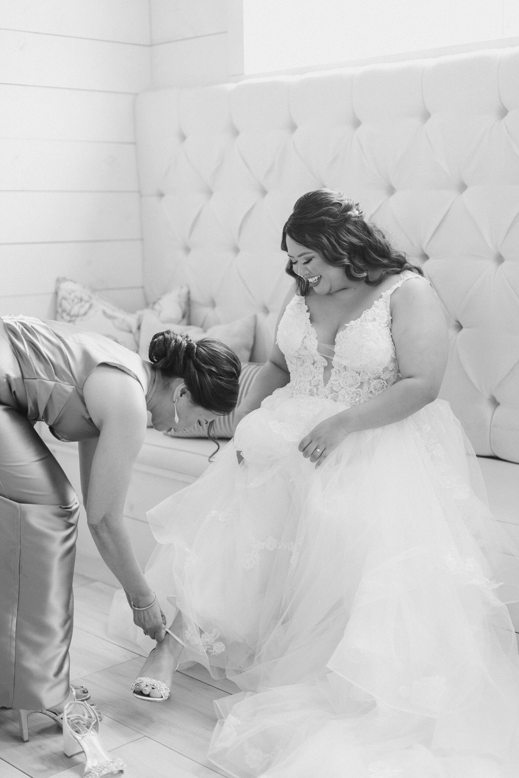 mother helps bride with shoes in bridal suite at The Nest at Ruth Farms