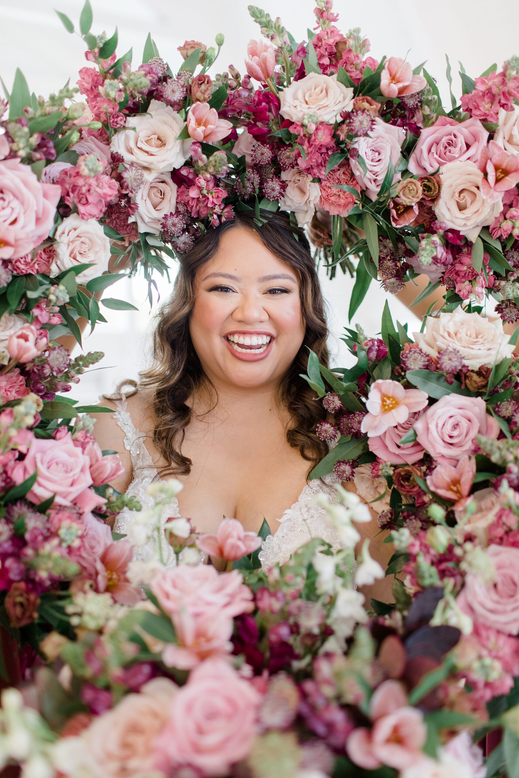 bride smiles with bouquets around her in frame 