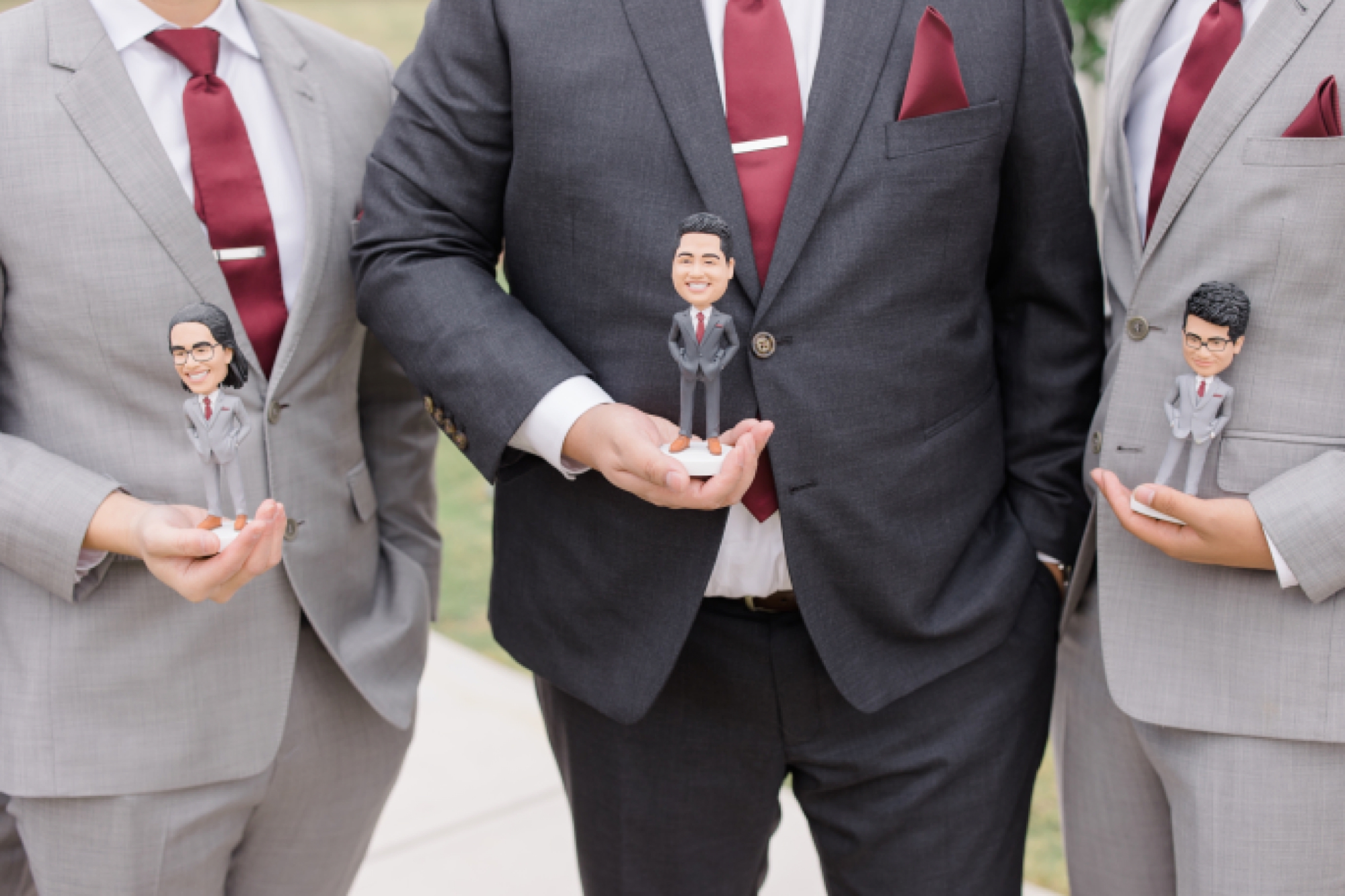 groomsmen and groom hold custom bobble heads 